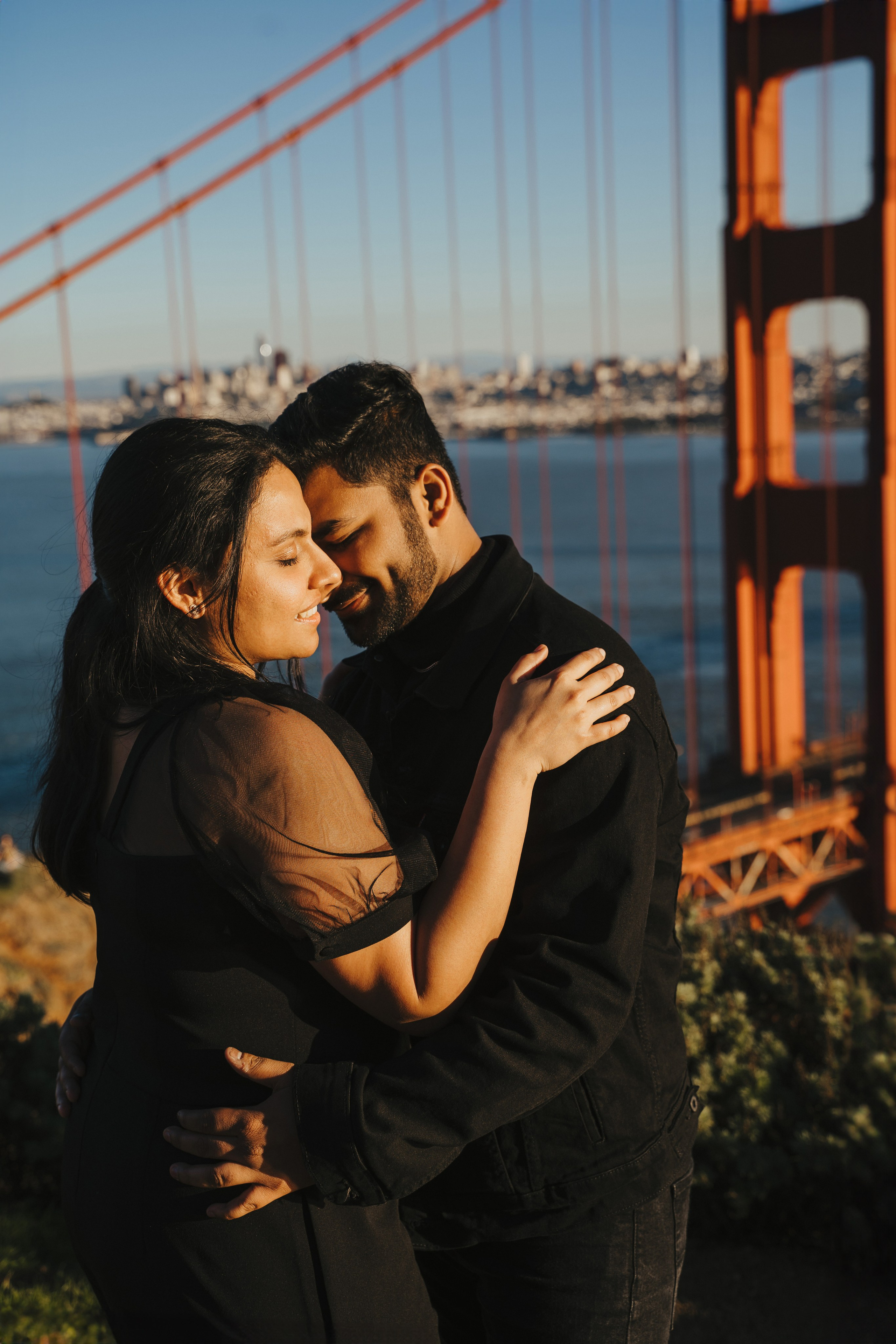 Proposal.  Overlooking the golden San Franisco Bridge sunset with a couple. Photographer Video. 