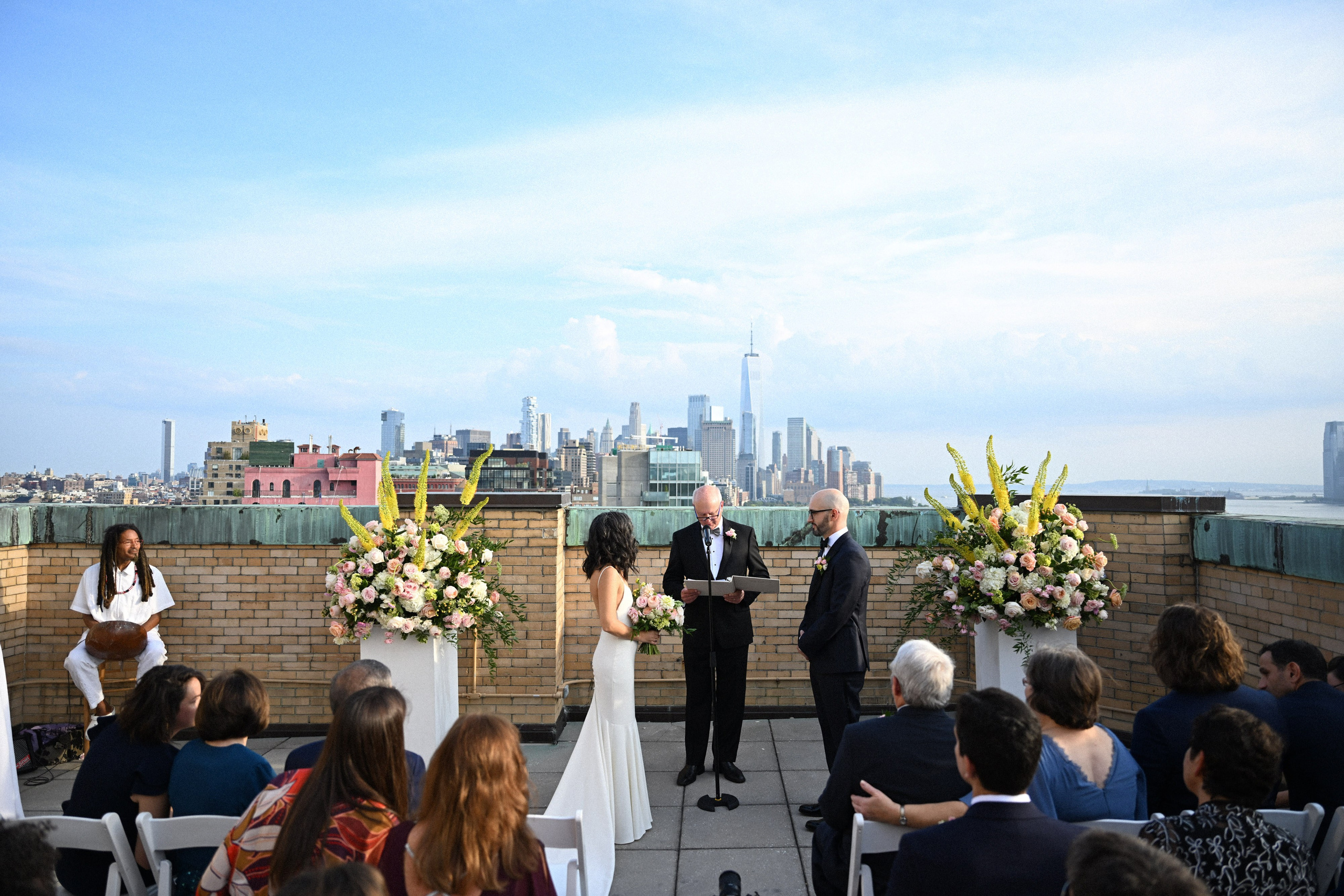 a couple getting married on a rooftop overlooking the city