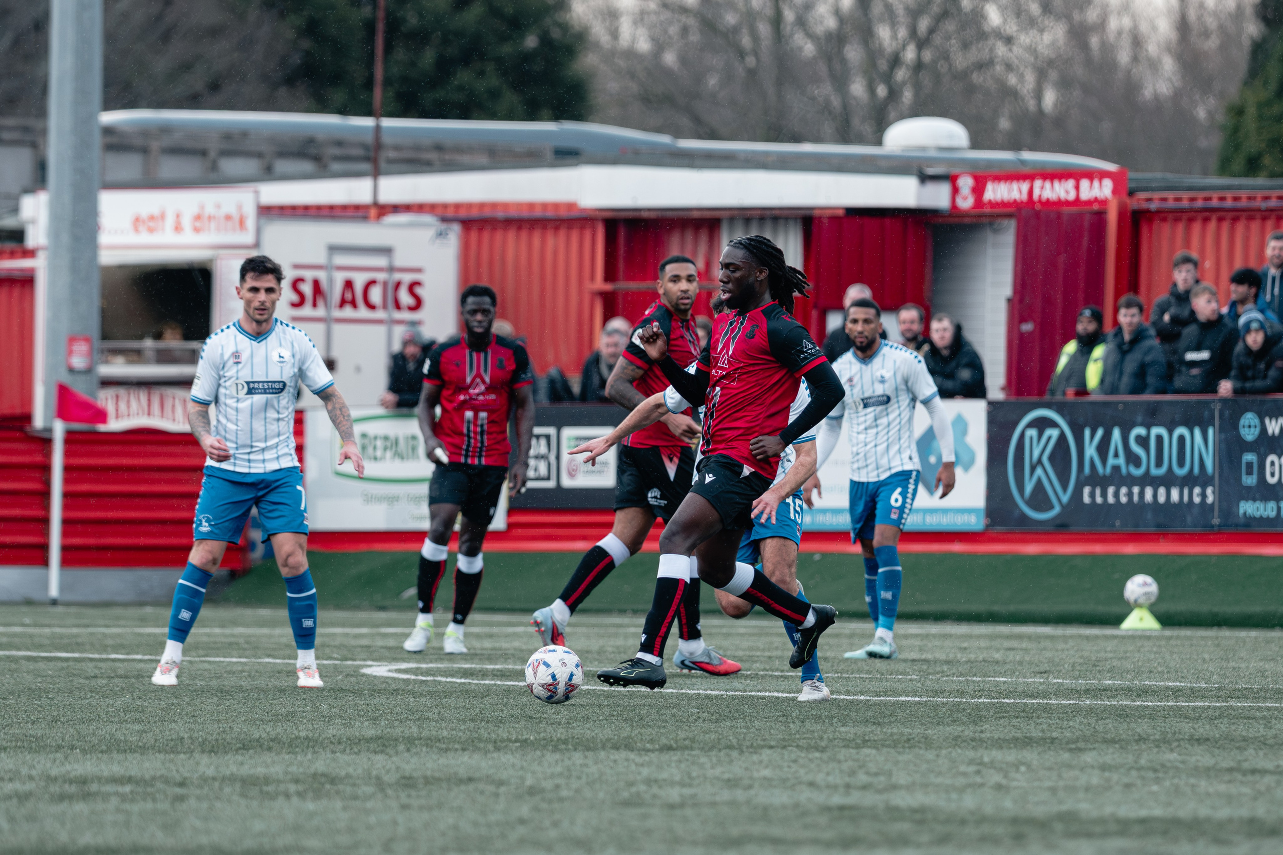 Michael Reindorf carries the ball forward with Hartlepool players closing in during the National League match at The Lamb Ground.
