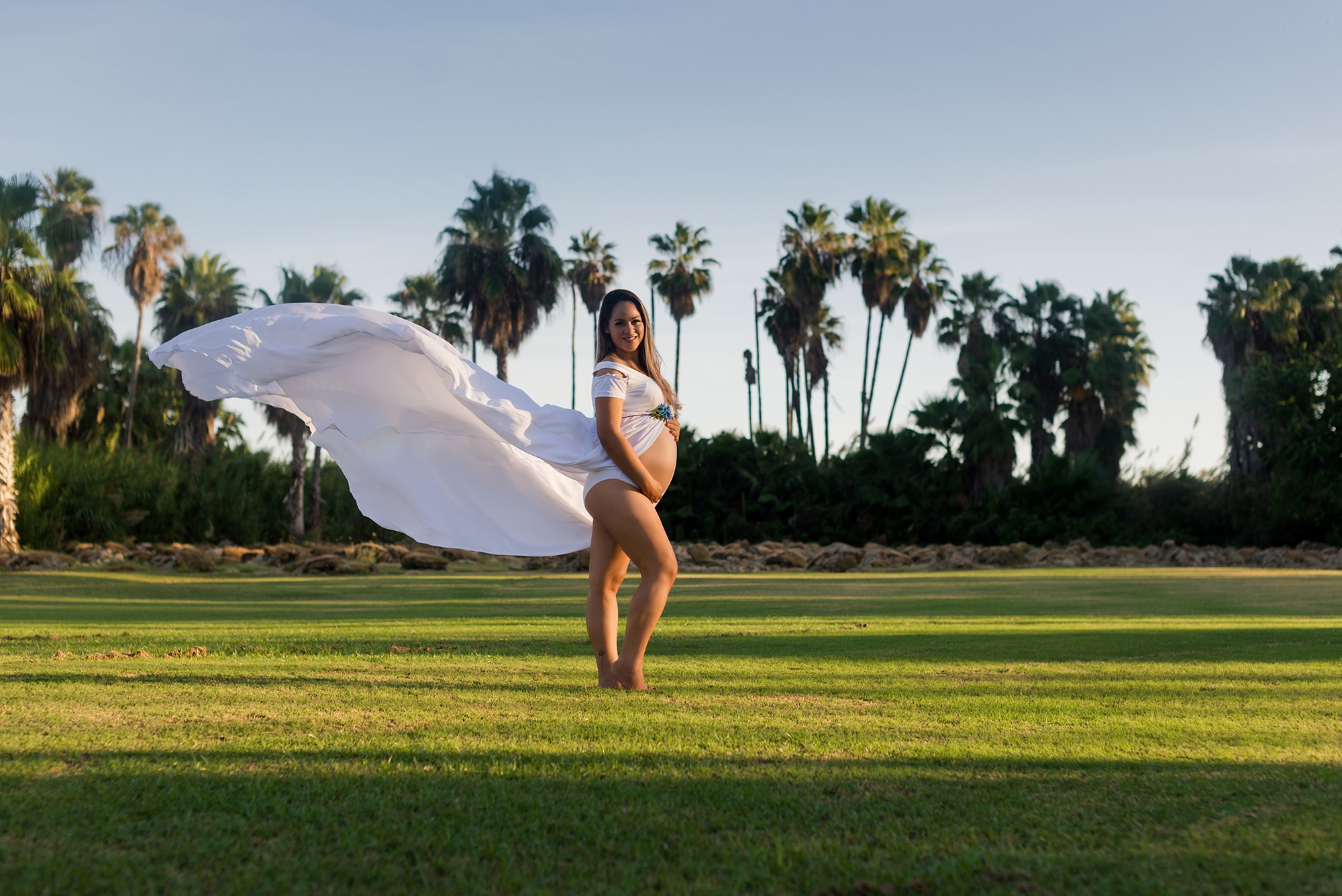 Maternity portrait in Los Cabos – pregnant woman looking at the camera with natural light, ocean and beach in the background, captured by Cabo maternity photographer
