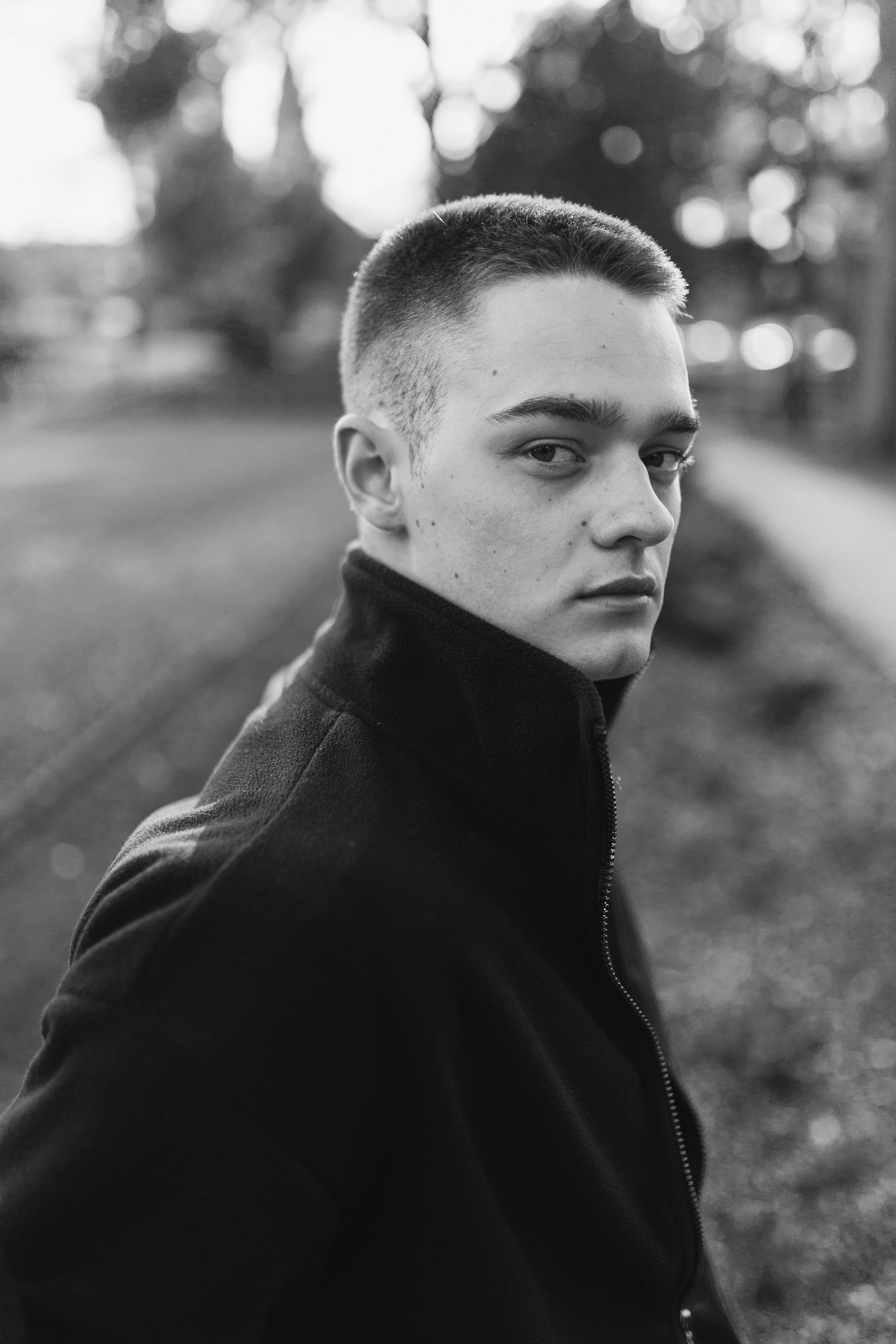 Black-and-white portrait of man looking over shoulder