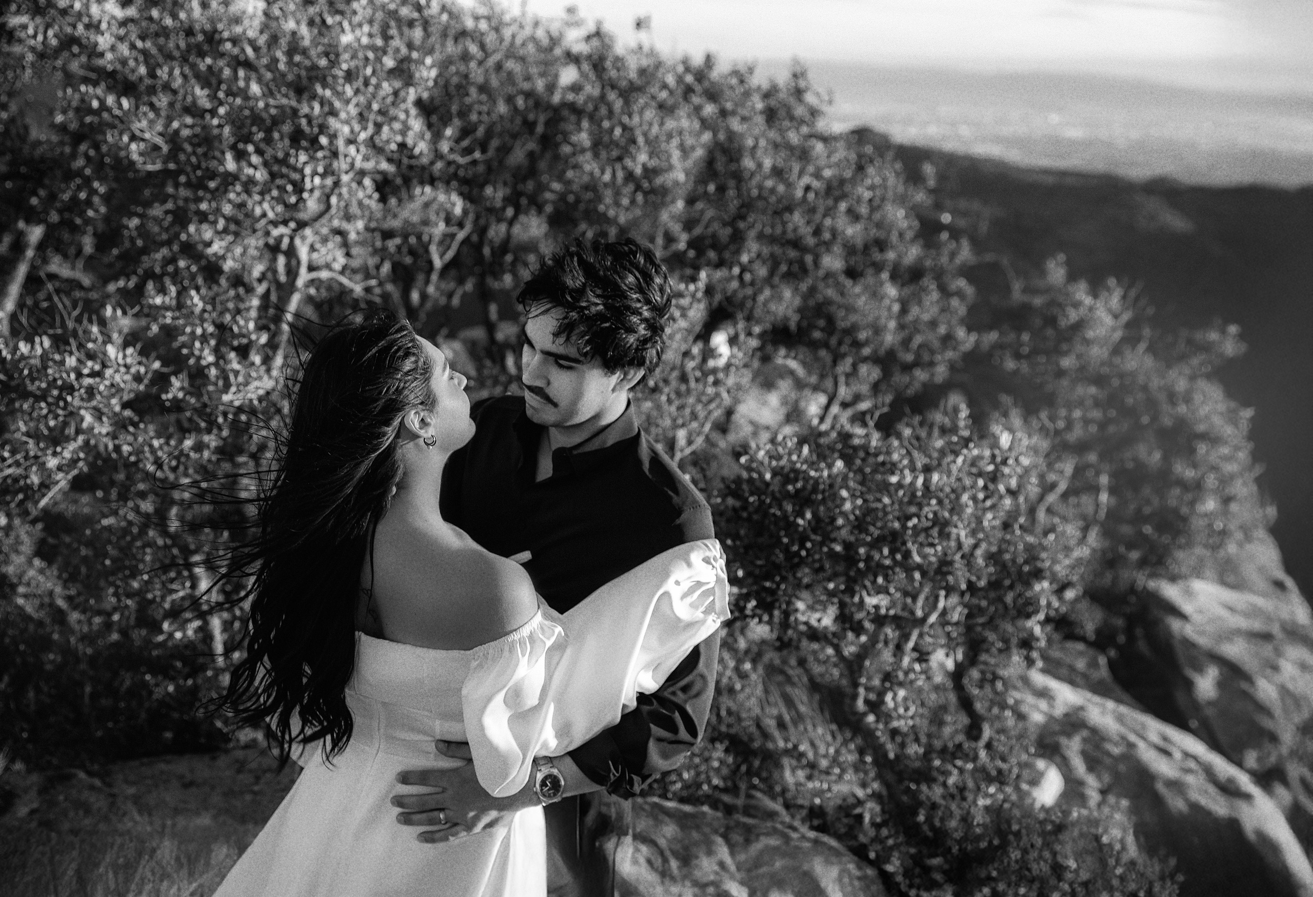 Bride and groom embracing among mountain trees during an intimate destination elopement in Barcelona, Spain. This romantic moment captures the emotion of a private civil wedding surrounded by nature at golden hour.