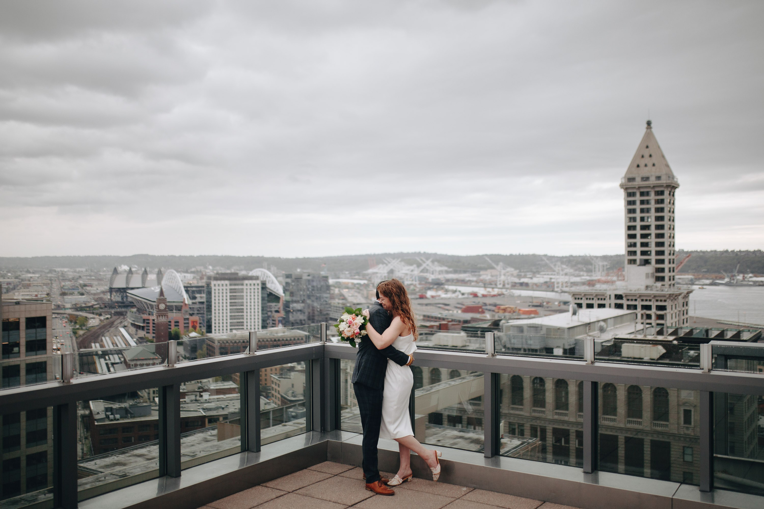 Bride on rooftop with city view, elegant wedding portrait