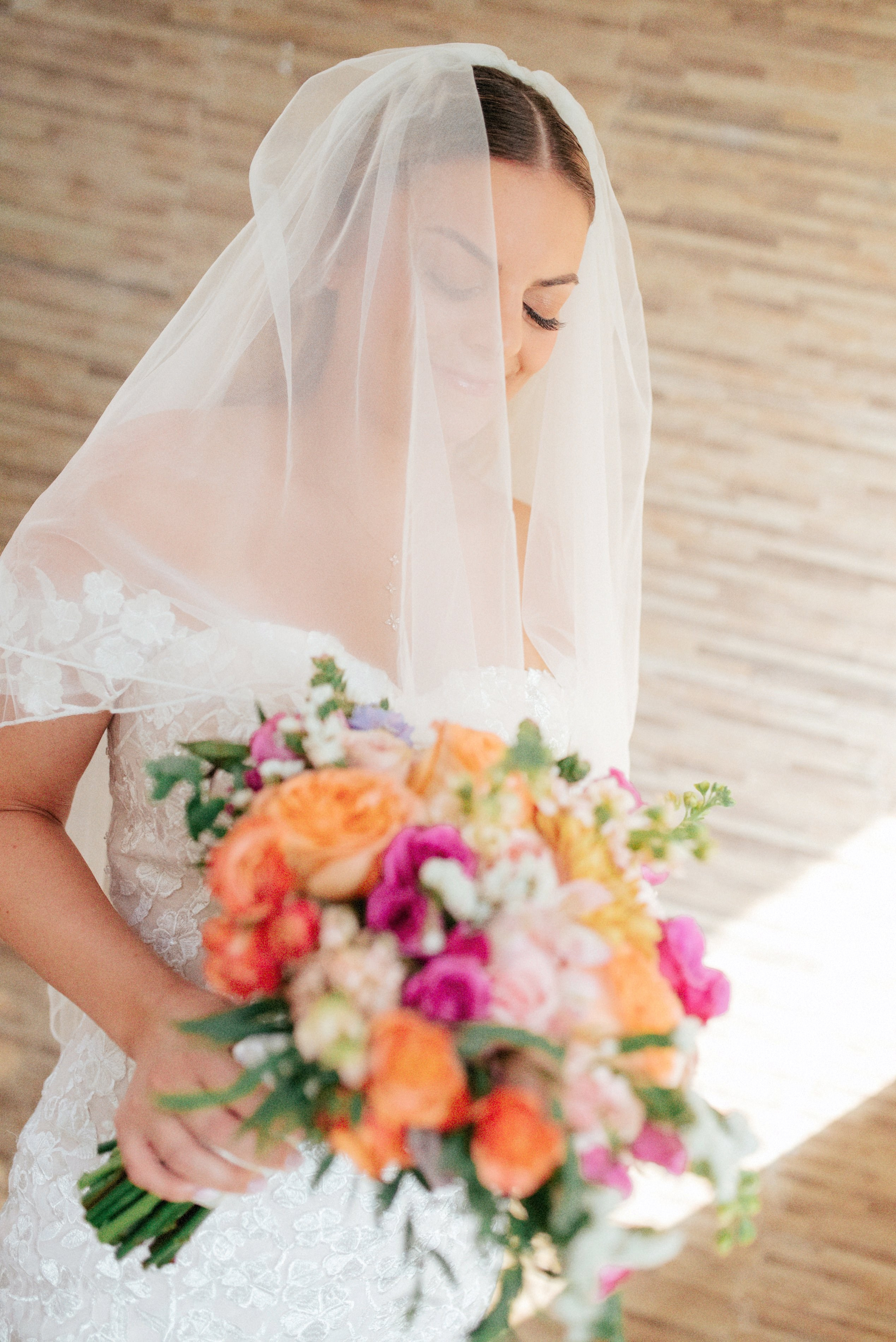 Bride holding bouquet – “Bride smiling and holding a colorful bouquet of flowers, high-quality wedding photography in Cartagena