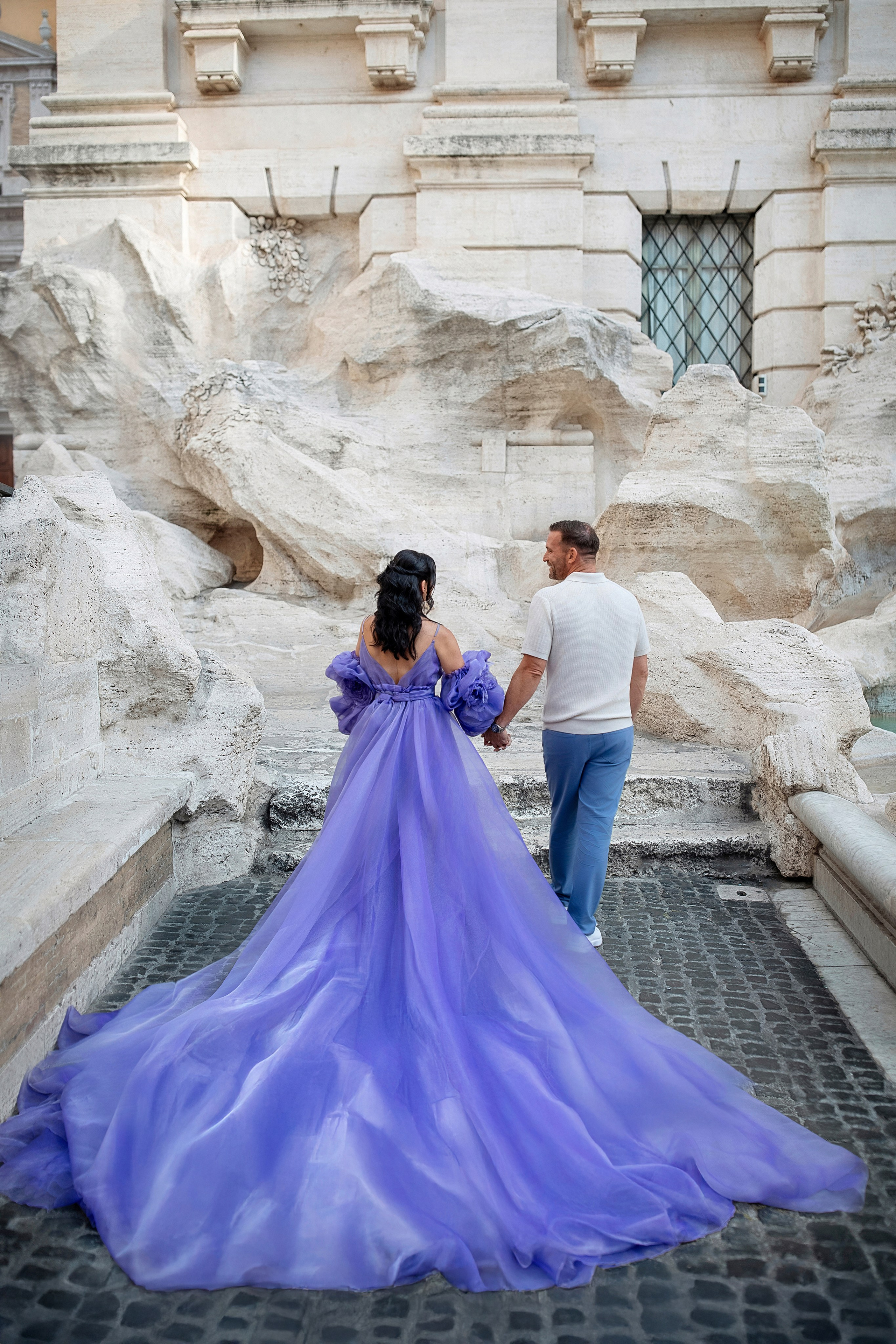 Couple photoshoot at the Trevi Fountain in Rome with the woman wearing a flying dress