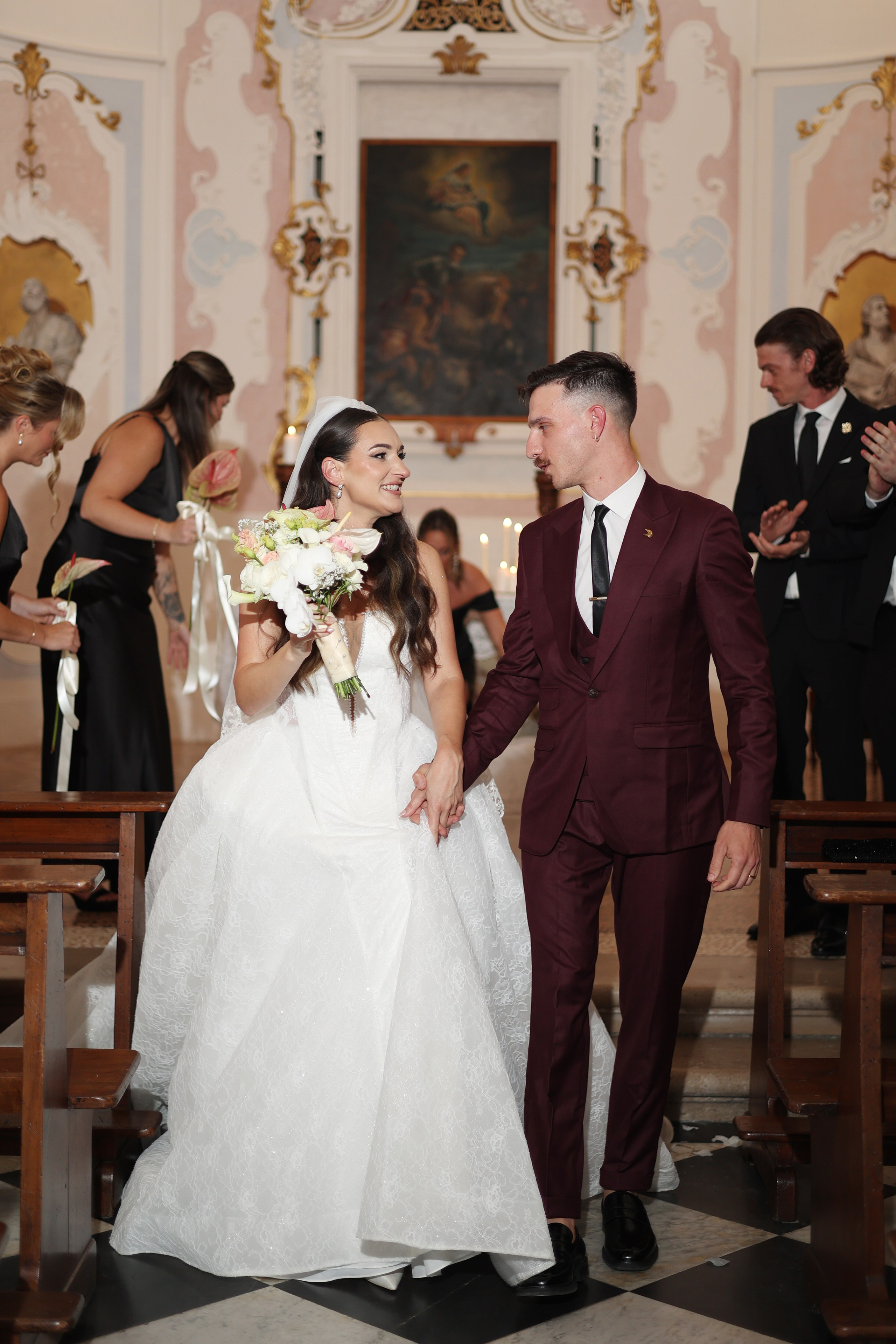 Bride and groom walking hand in hand in the castle courtyard.