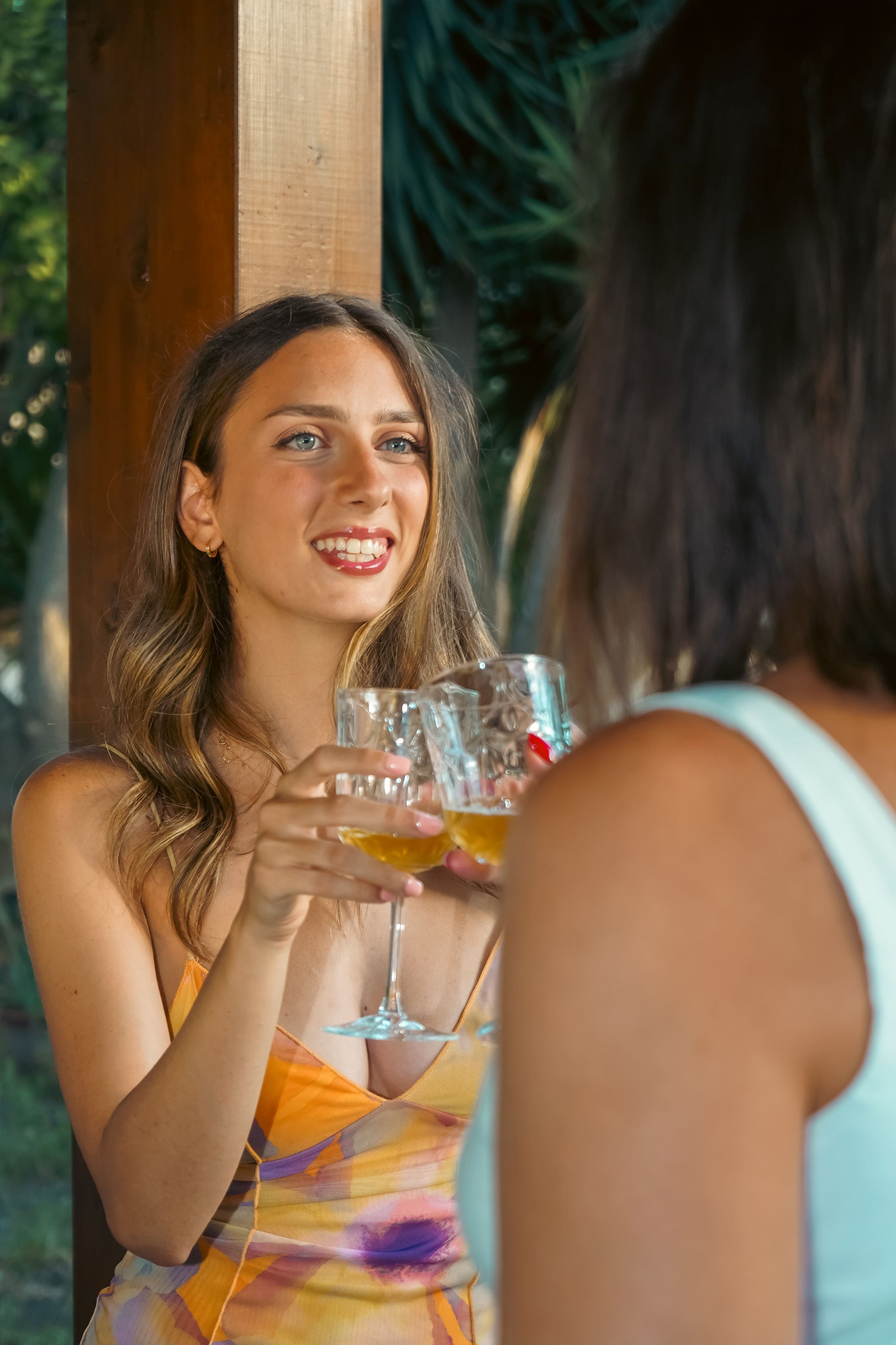 Fotografo eventi Napoli – festa privata due amiche che parlano coi calici in mano