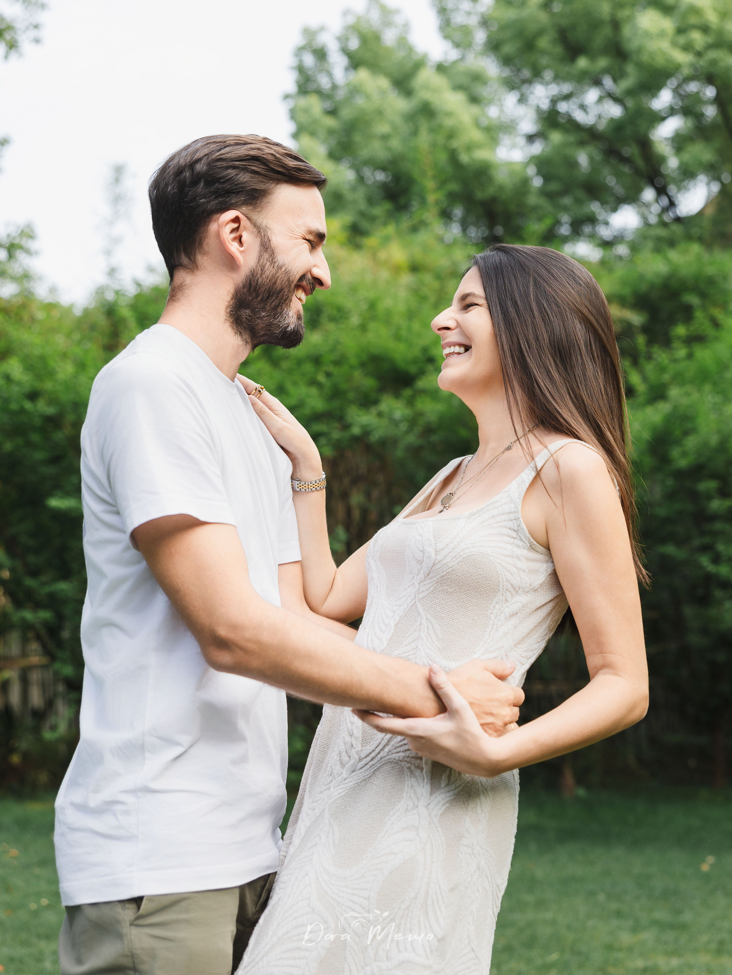 Parents embracing in the garden | Parents sharing a quiet embrace while their children play nearby
