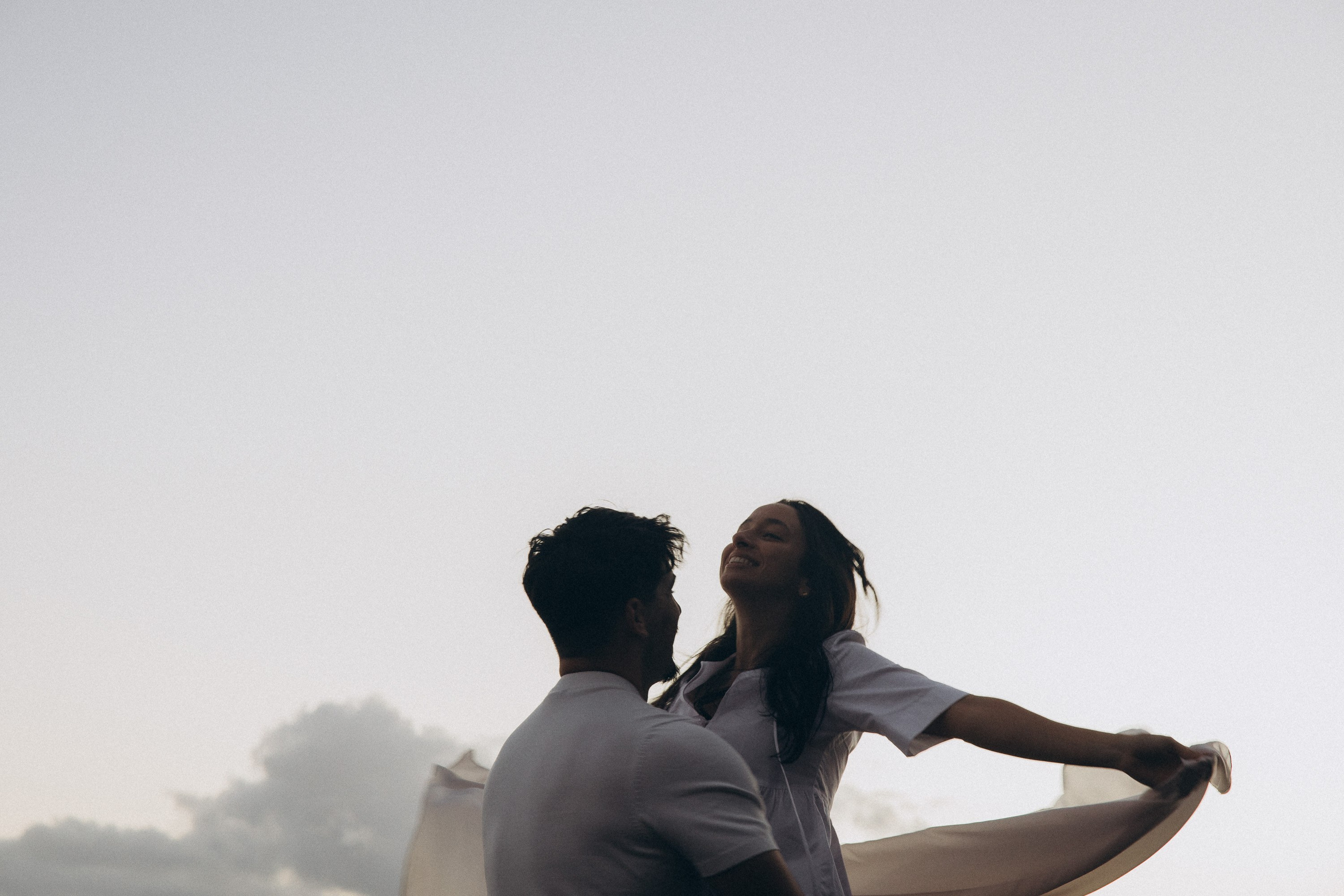 Couple sharing a romantic moment during sunset on Madeira Island, with the ocean and cliffs in the background