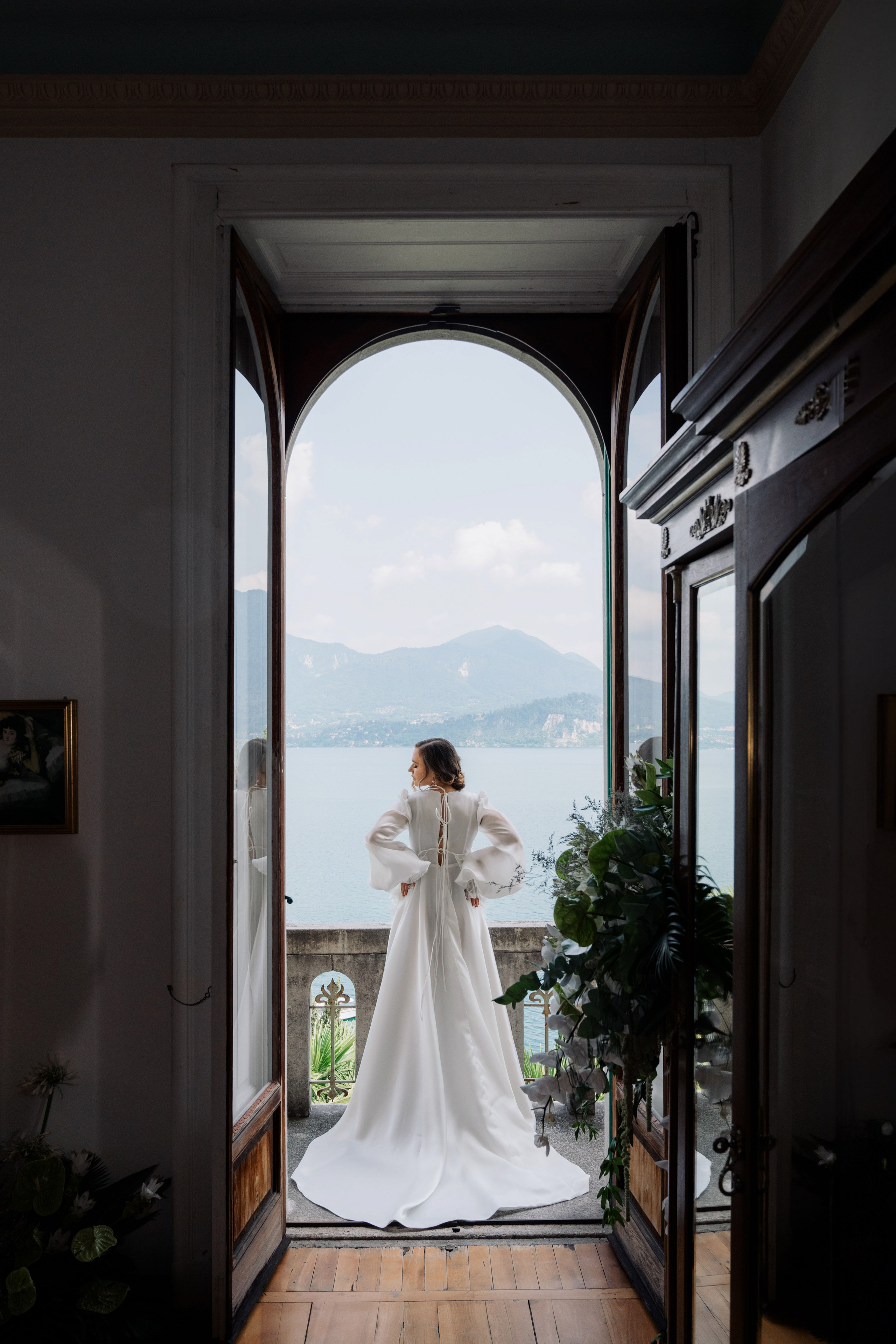 a woman in a wedding dress is standing in an open doorway