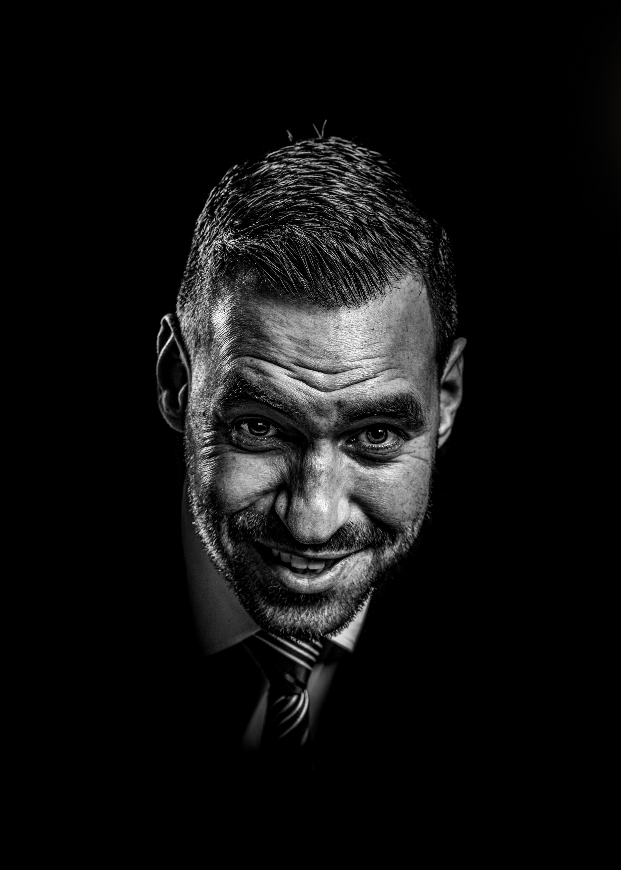 High-contrast black and white portrait of a man with an expressive facial expression