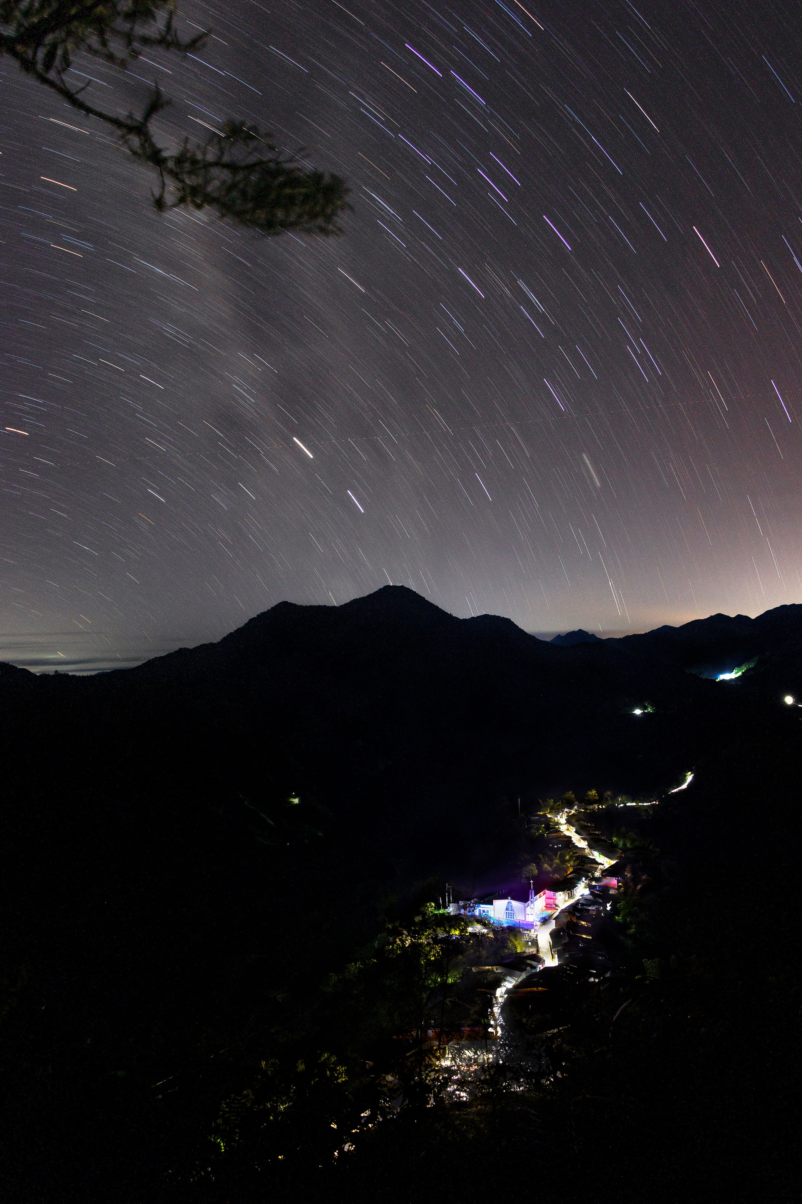 Paisaje de un pueblo con trazo de estrellas en el cielo y montañas