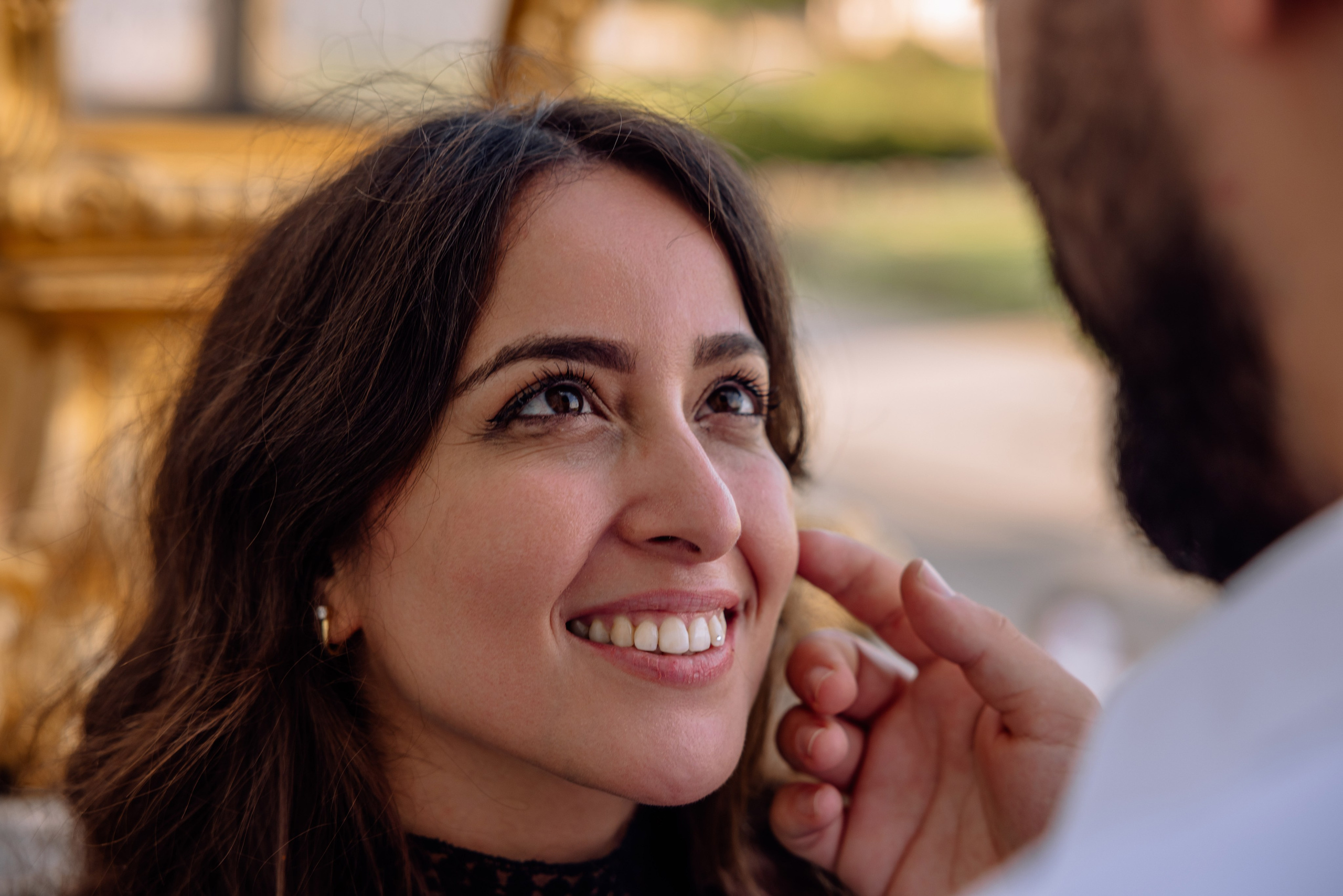 Nahaufnahme des Gesichts der Braut voller Freude vor dem Schloss Nymphenburg