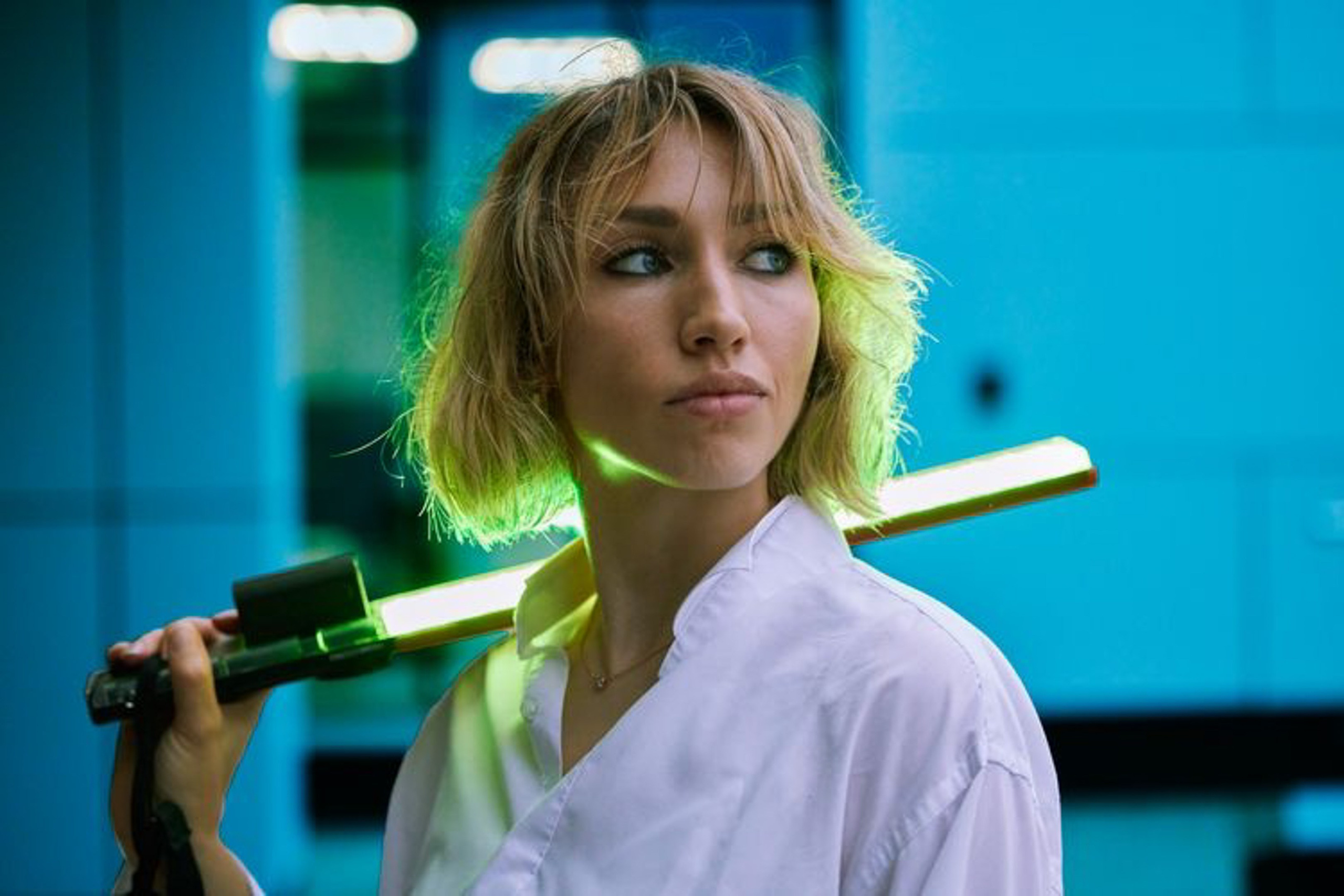 Location portrait of a young woman with colored lighting against the backdrop of a building - photographer Andrey Dunin