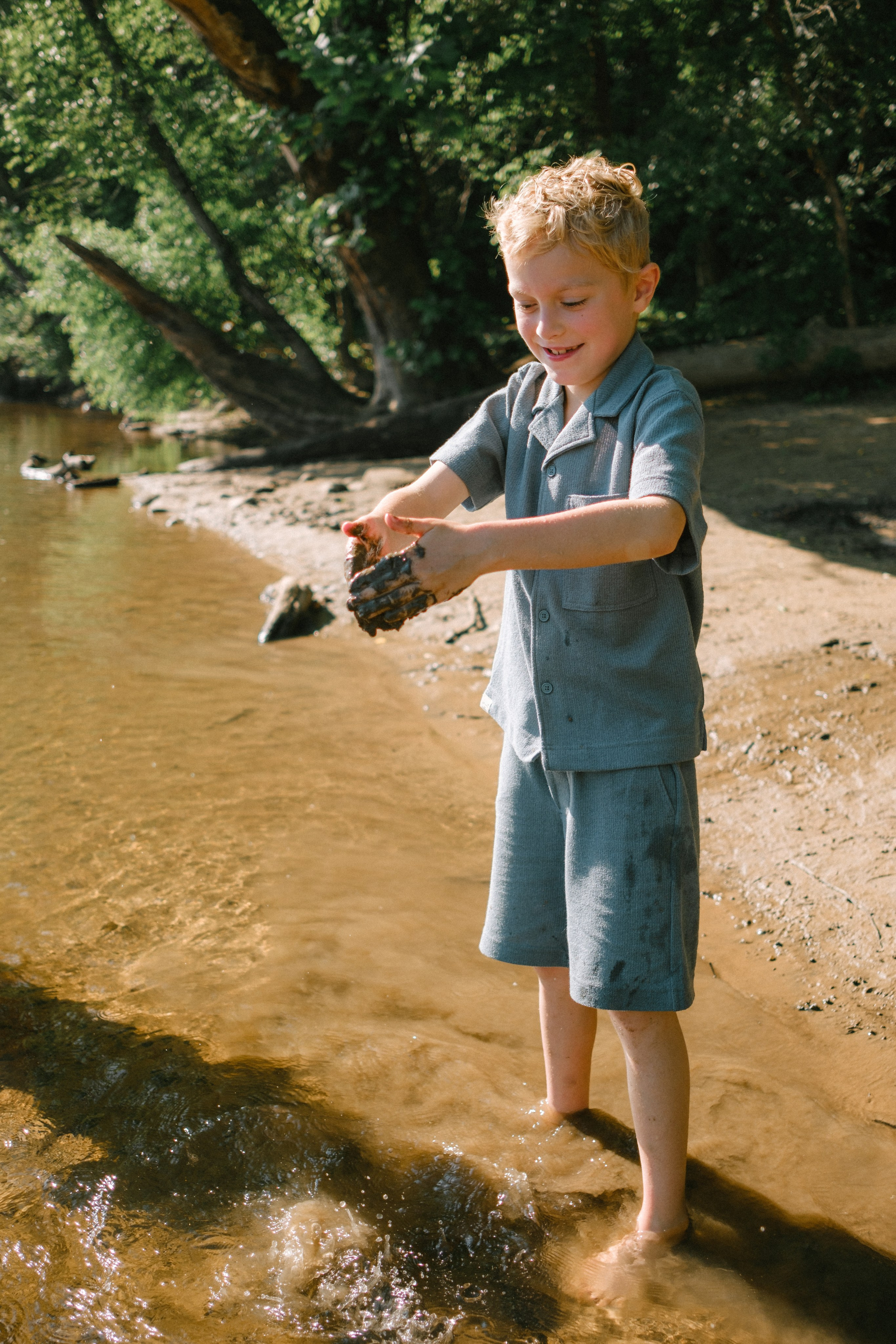 Kids playing in the mud during an adventurous outdoor family photography session at Pony Pasture