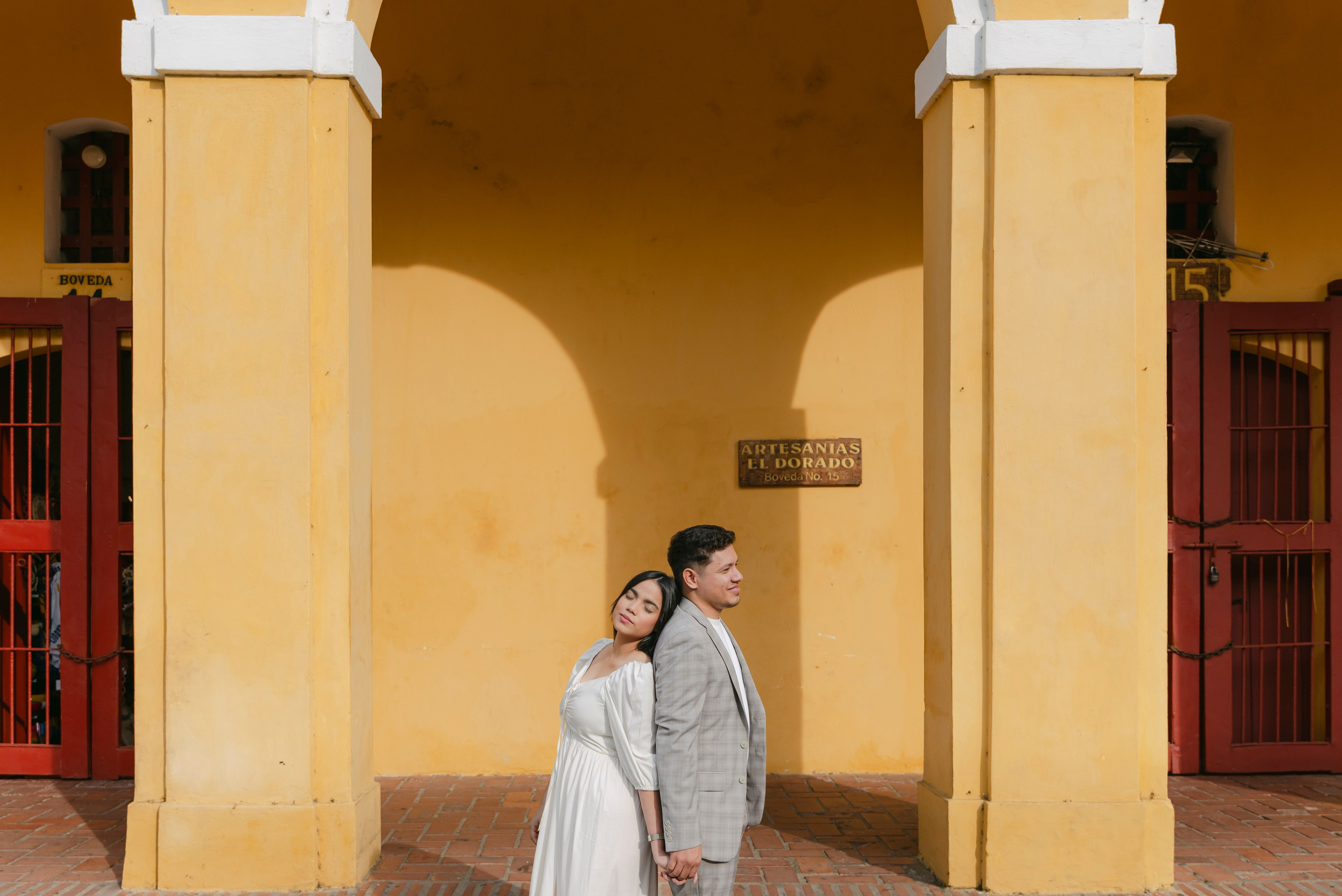 Detalle de pareja en arcos coloniales, fotografía cinematográfica de preboda en Cartagena