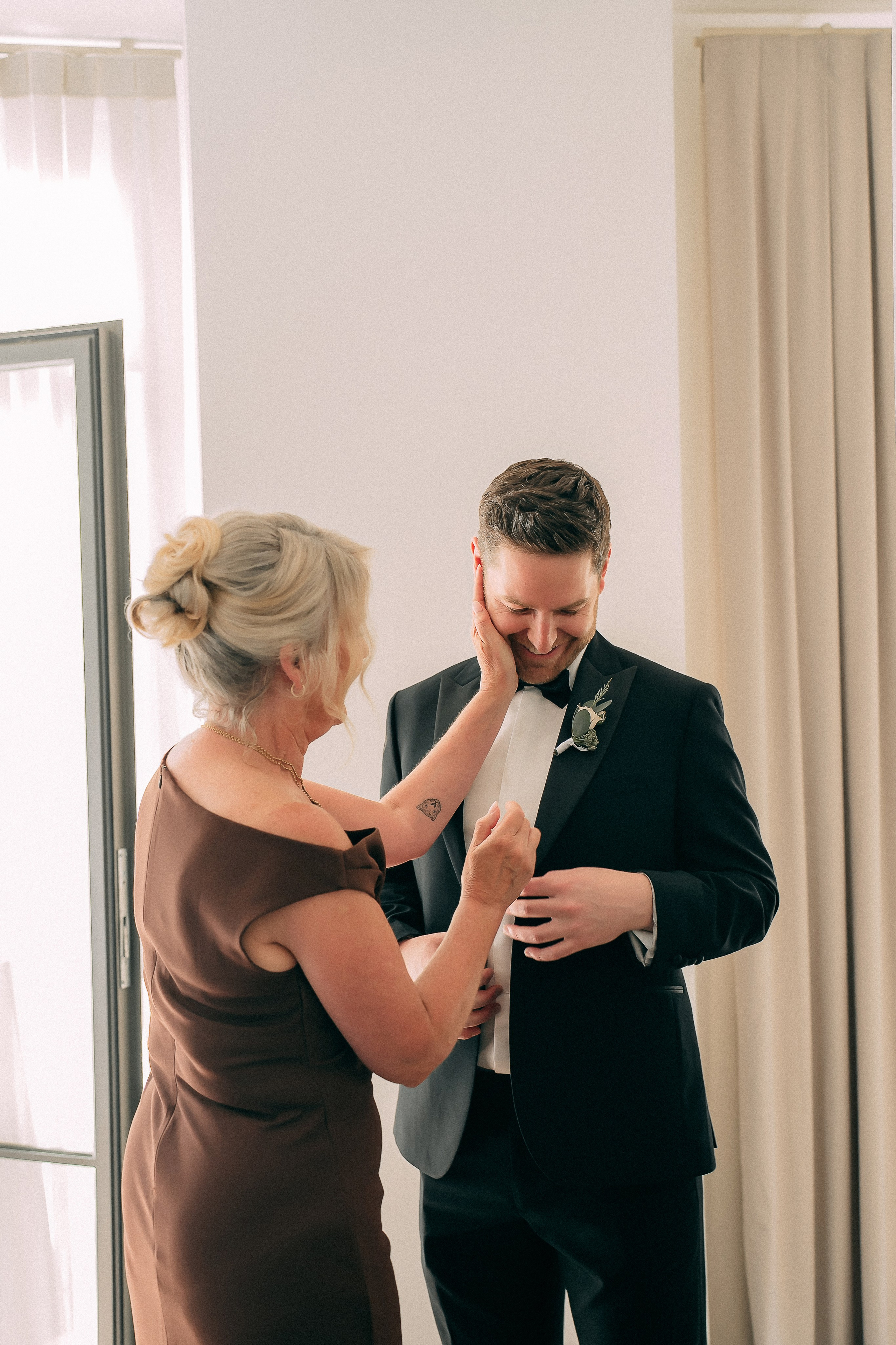 Groom helping the bride with her earrings before their Lake Como wedding at Villa Lario, Italy
