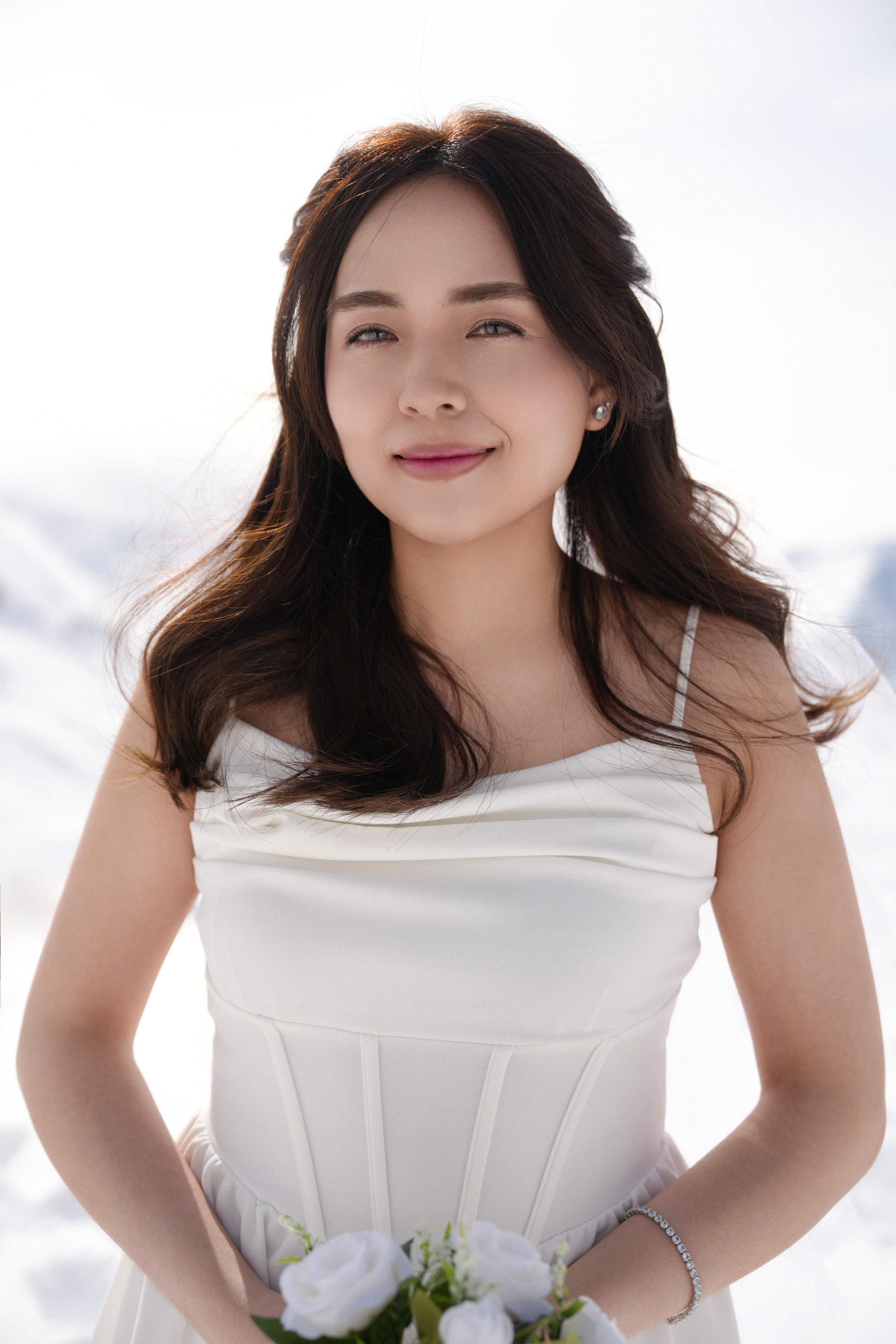Bride holding flowers in the snowy Gudauri mountains