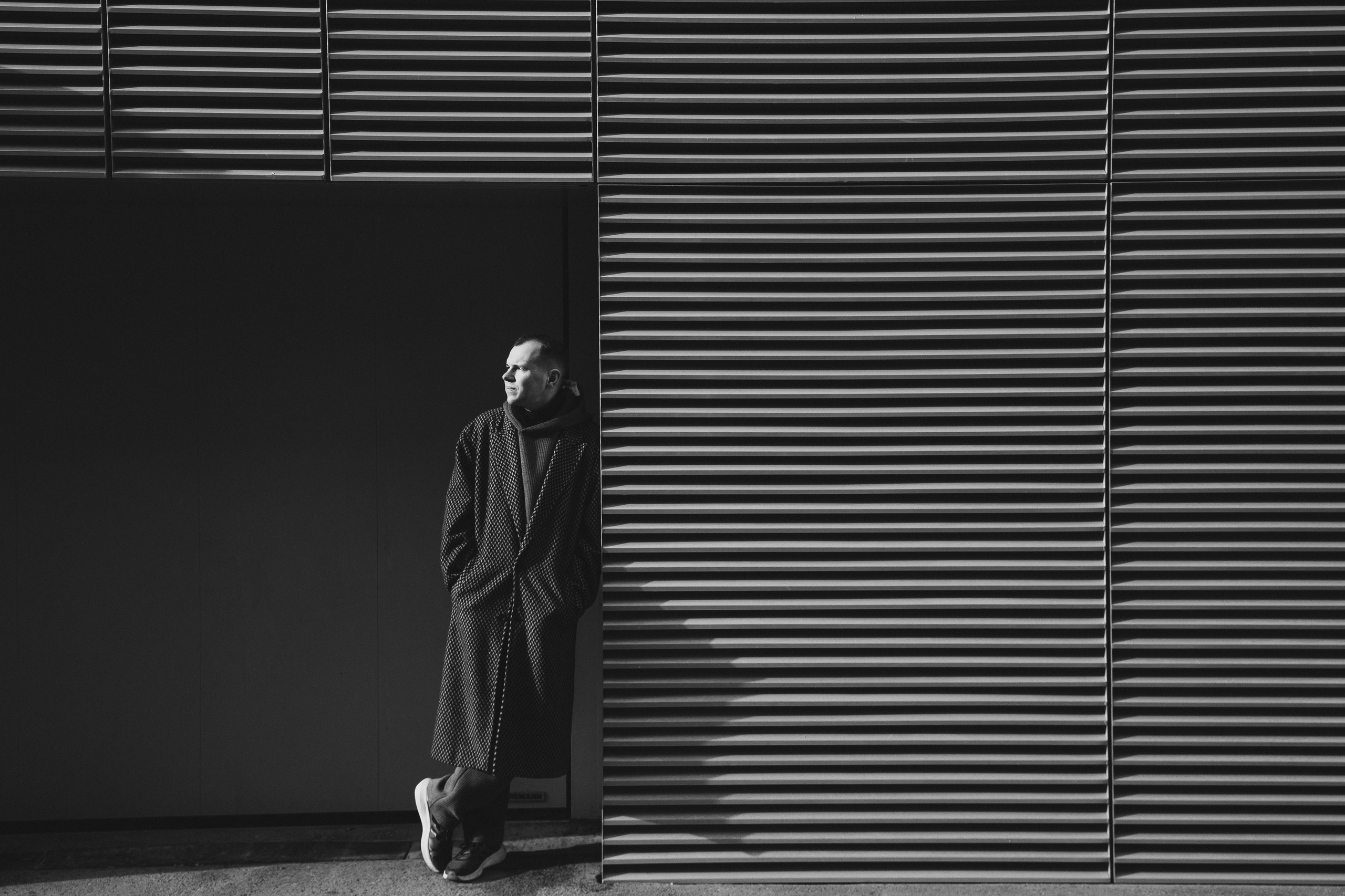 black and white male portrait in Budapest at a striped building