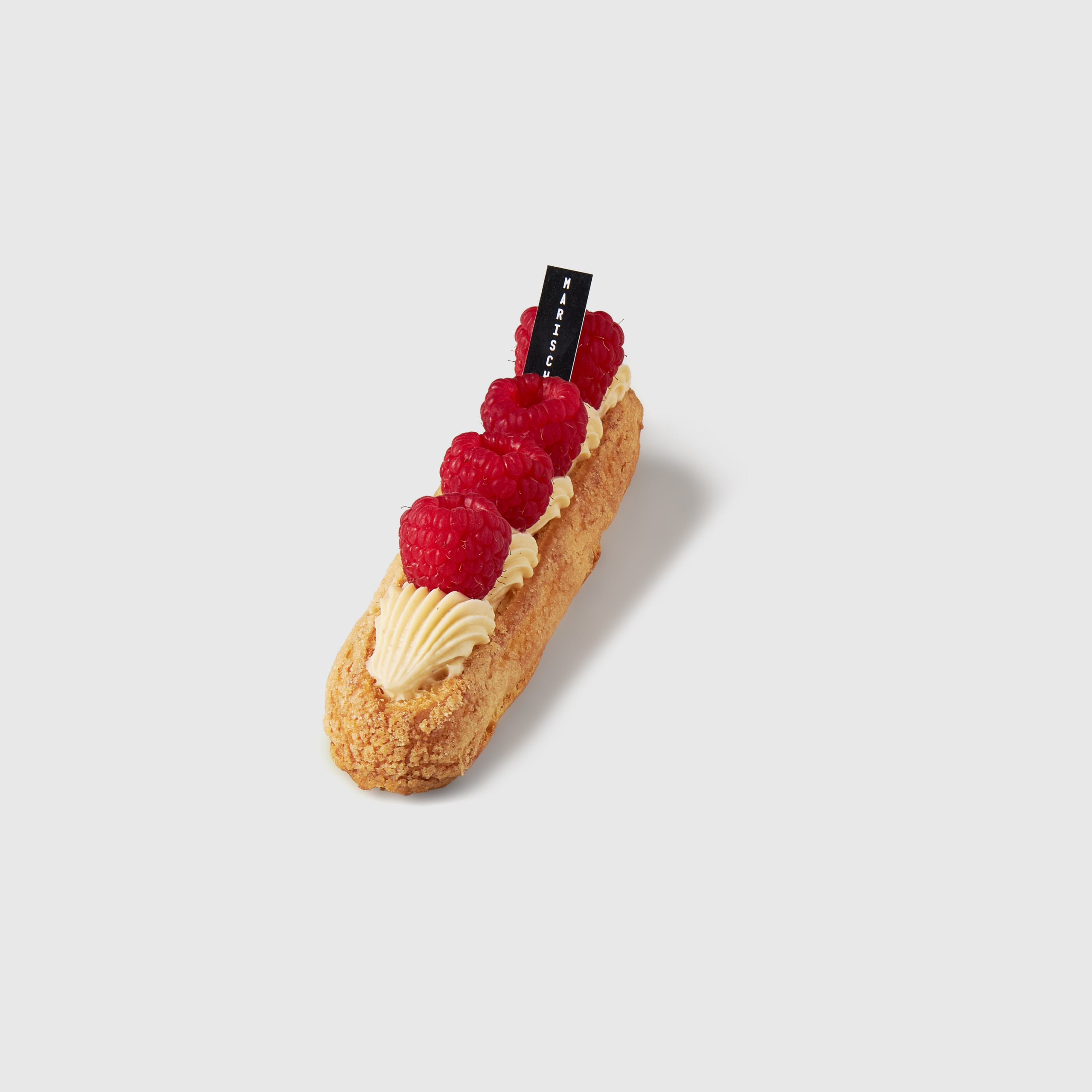Katalogfoto eines Eclairs mit Himbeere auf neutralem Hintergrund, professionelle Produktfotografie für Menü, Online-Shop und Print