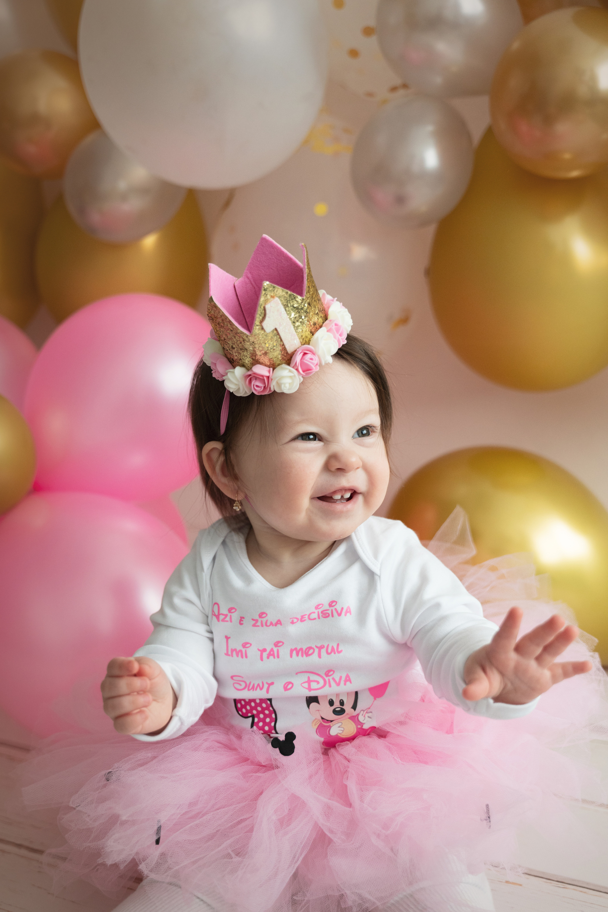 Ein Mädchen in einem eleganten rosa Rock mit einer schönen Krone auf dem Kopf lacht