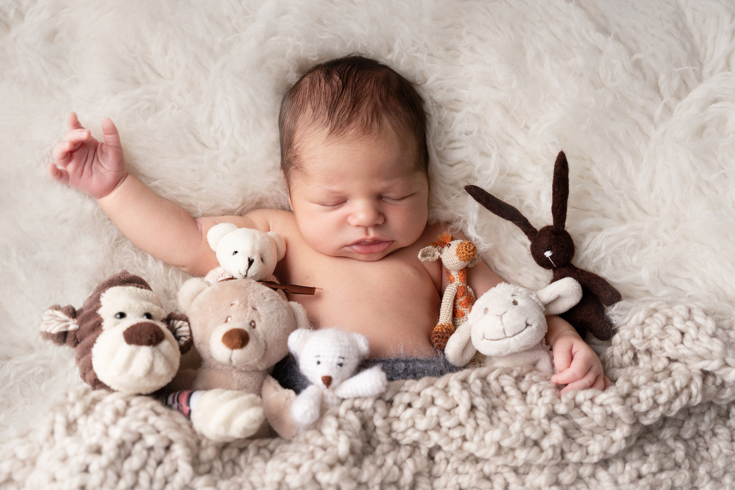 baby schläft in einer Umarmung mit Spielzeug