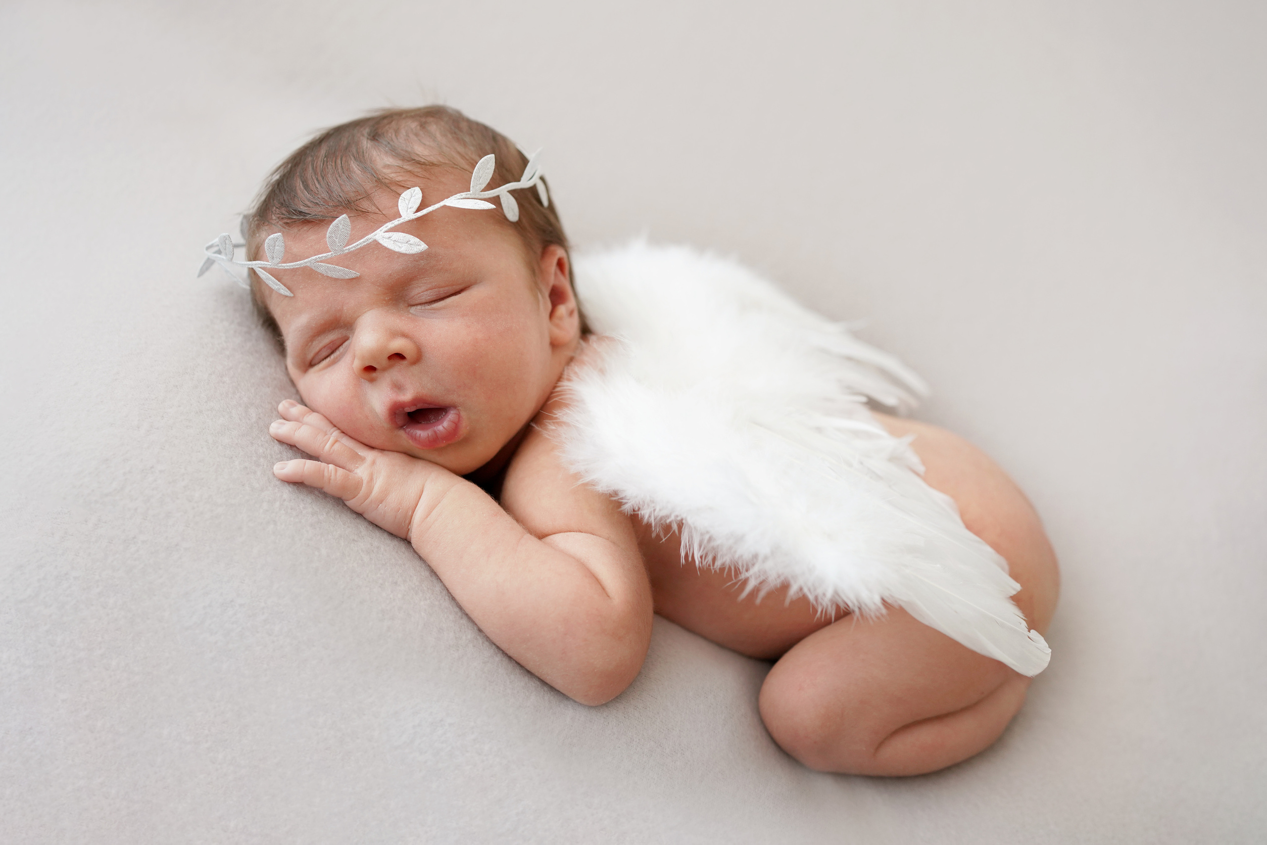 das Bild eines schlafenden Engels mit Flügeln bei einer Neugeborenen-Fotosession