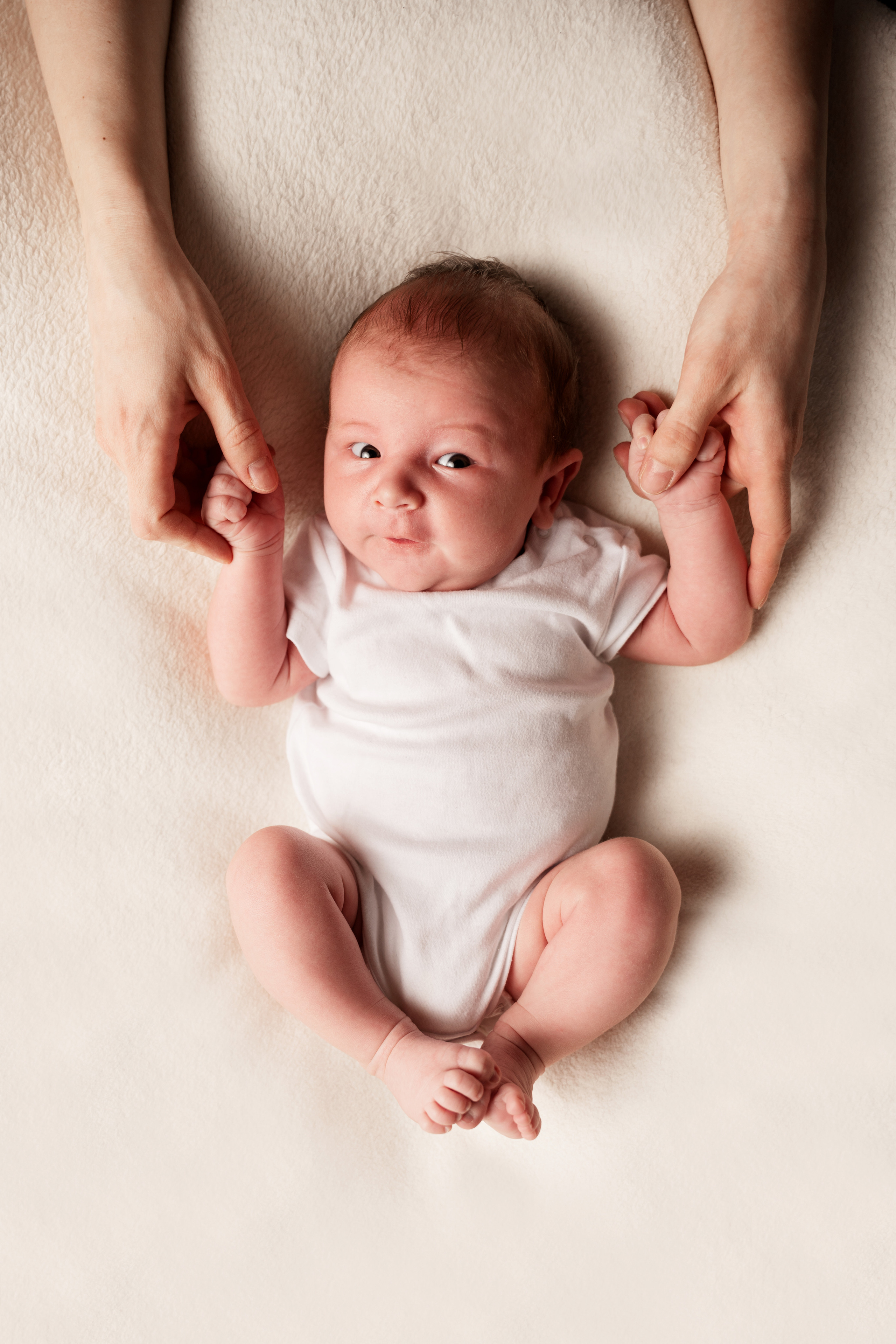 der junge im weißen anzug liegt auf dem rücken und zieht seine beine an den bauch