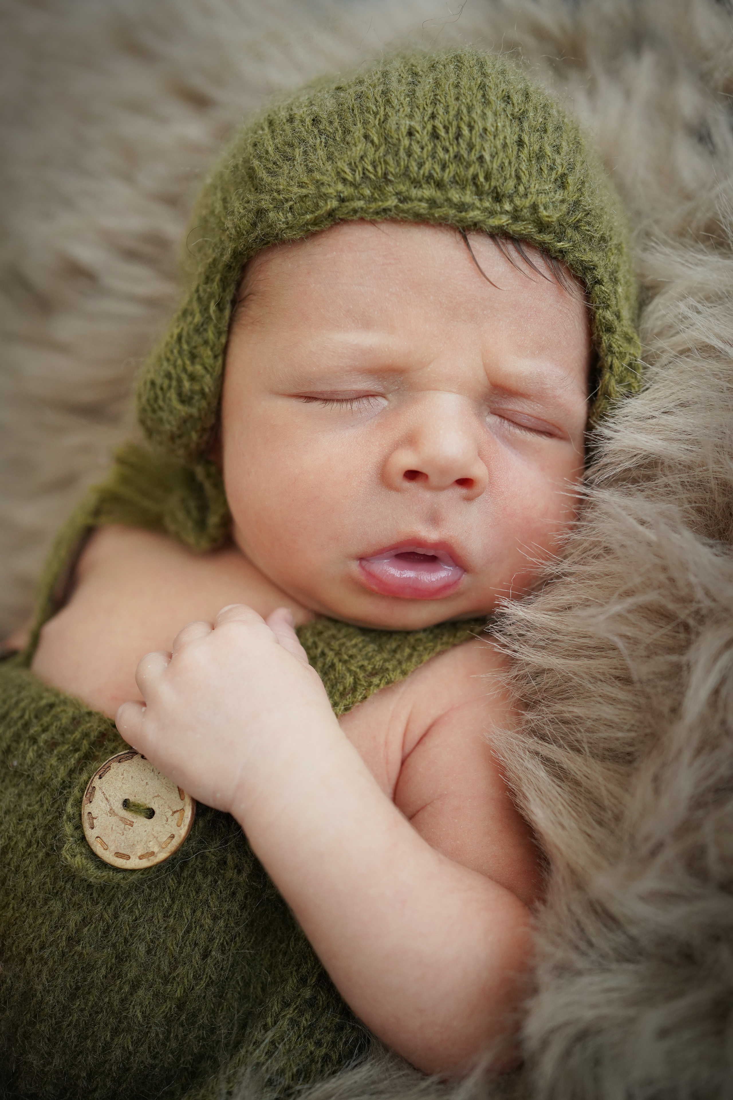 Schlafendes Baby in einem grünen Hut