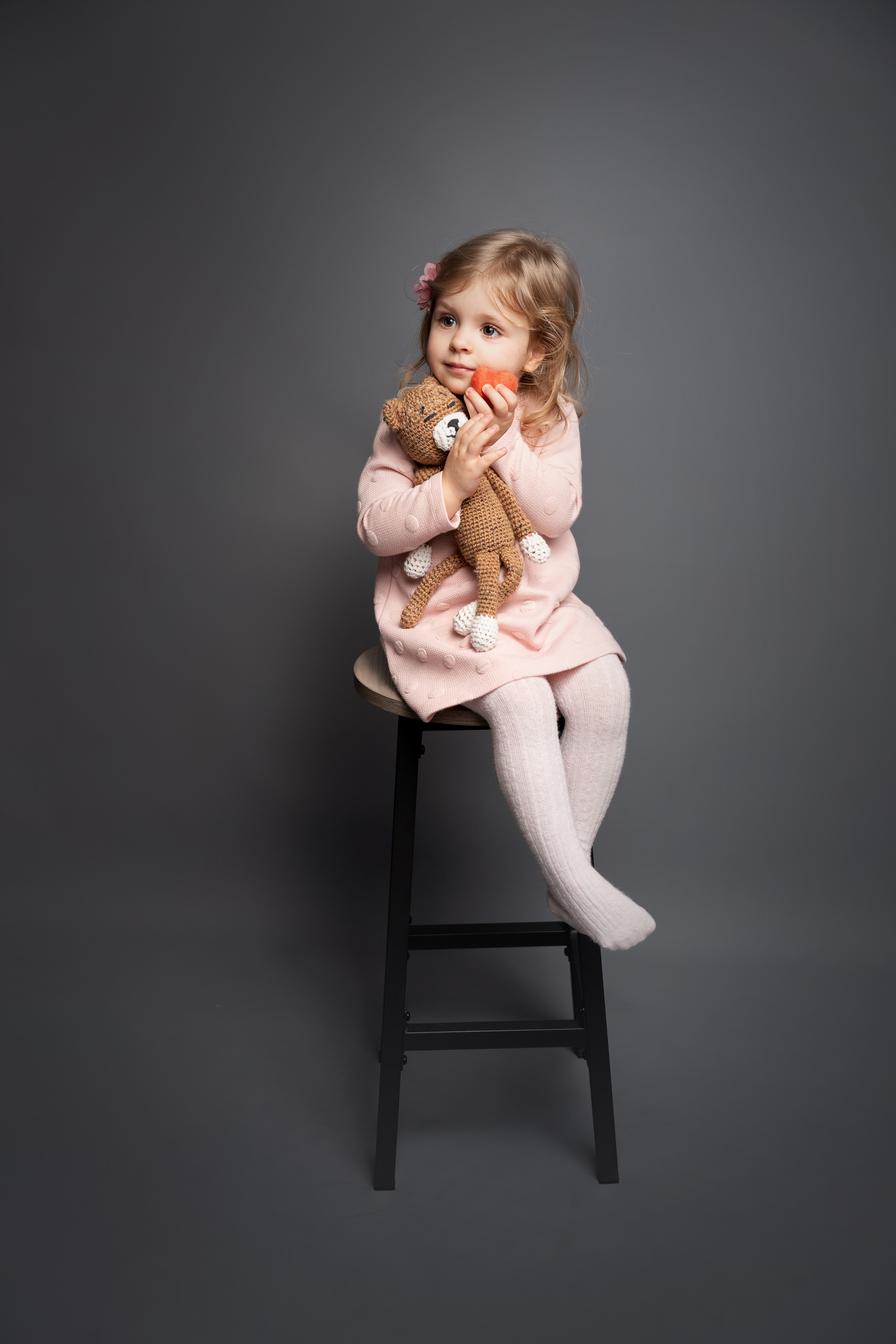 kleines Mädchen posiert auf einem Barhocker im Studio
