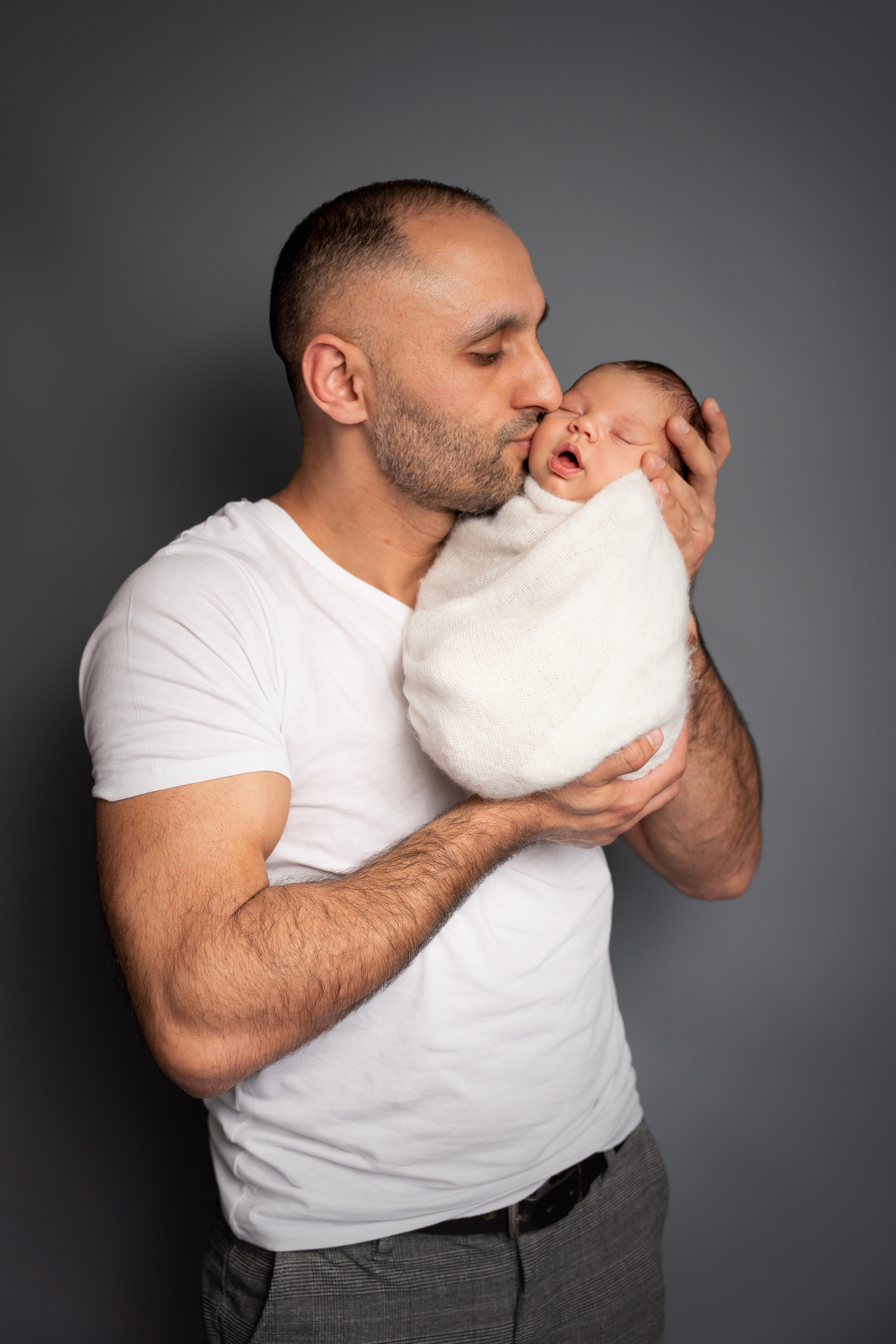 papa küsst seinen neugeborenen sohn