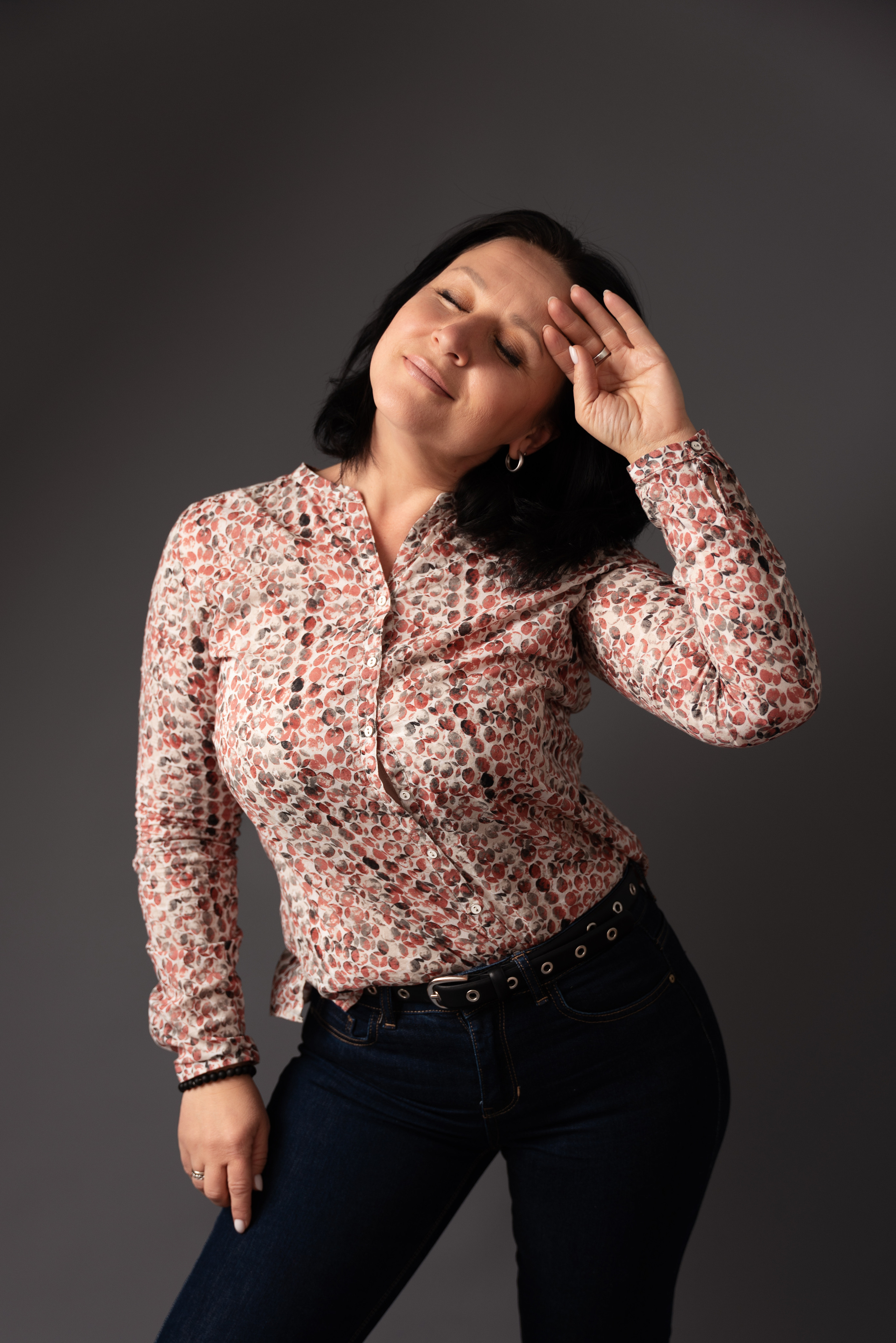 eine frau schaut in den rahmen und glättet ihr haar mit der hand