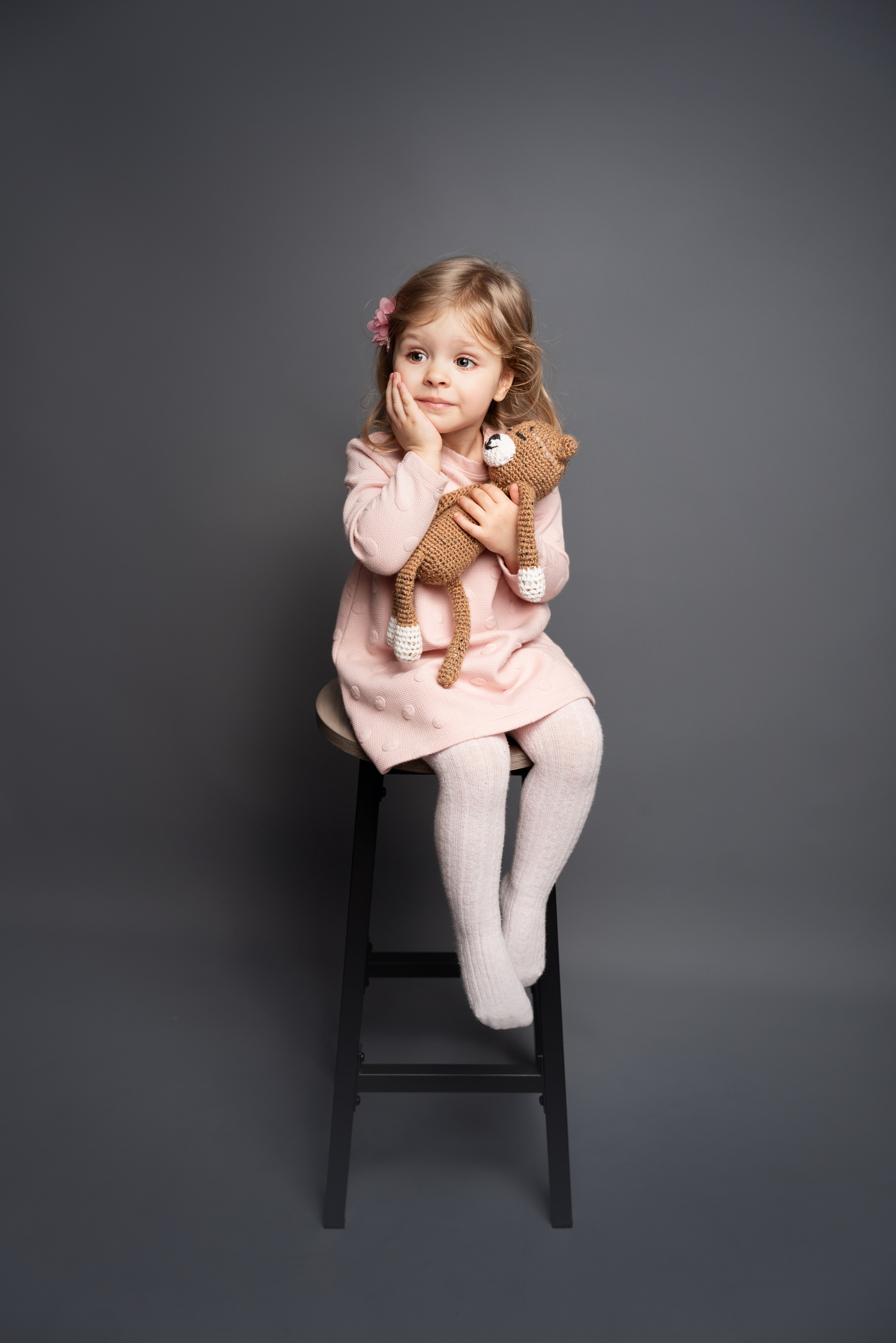 Mädchen sitzt auf einem Stuhl und wundert sich