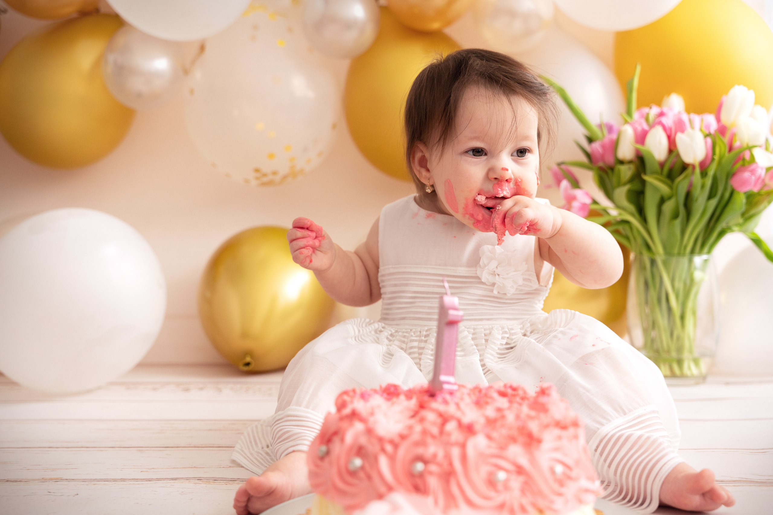 Das Kind isst den Kuchen mit seinen Händen und schmiert sein Gesicht mit Sahne