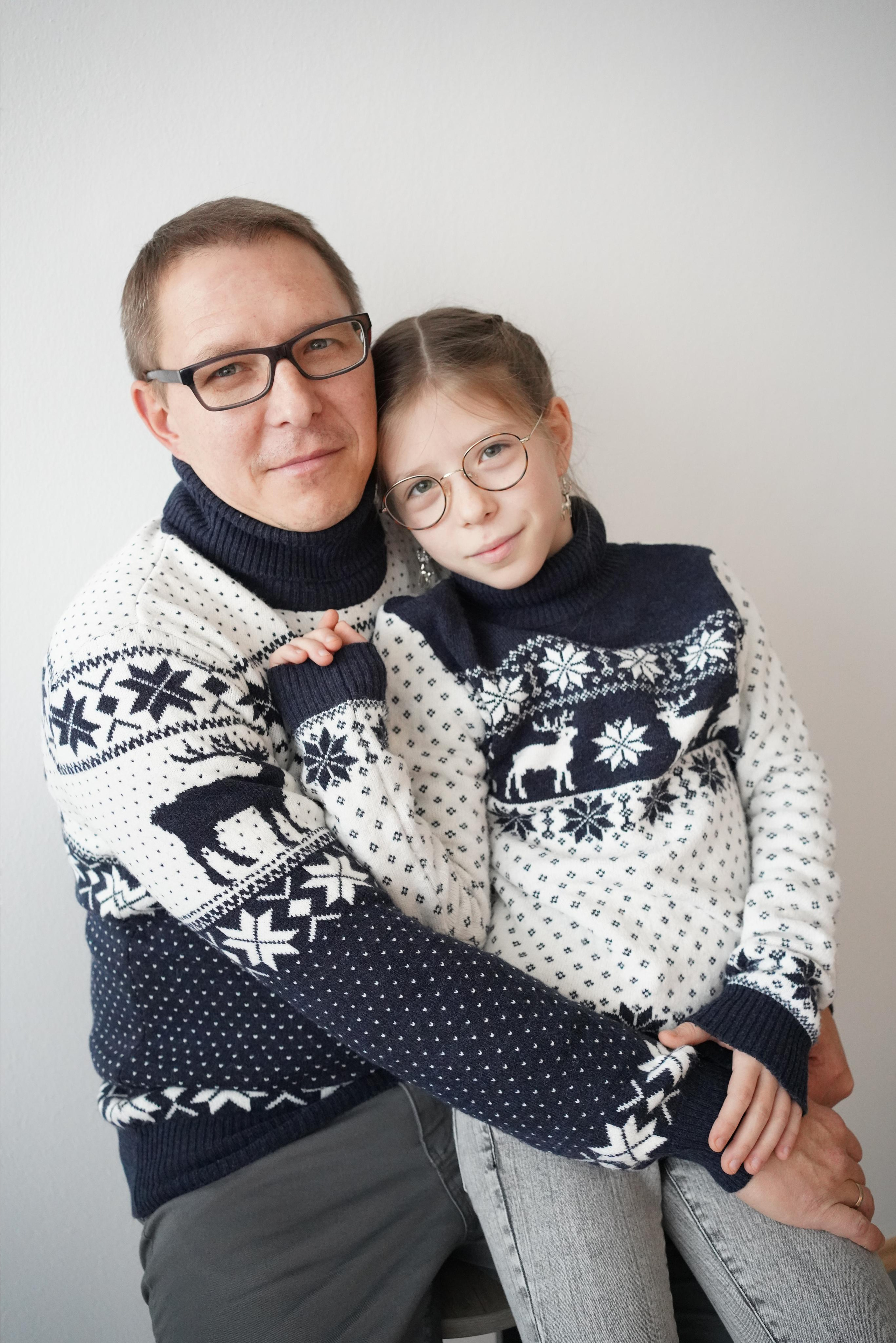 Ein Vater hält eine erwachsene Tochter in seinen Armen und sie tragen die gleiche Kleidung