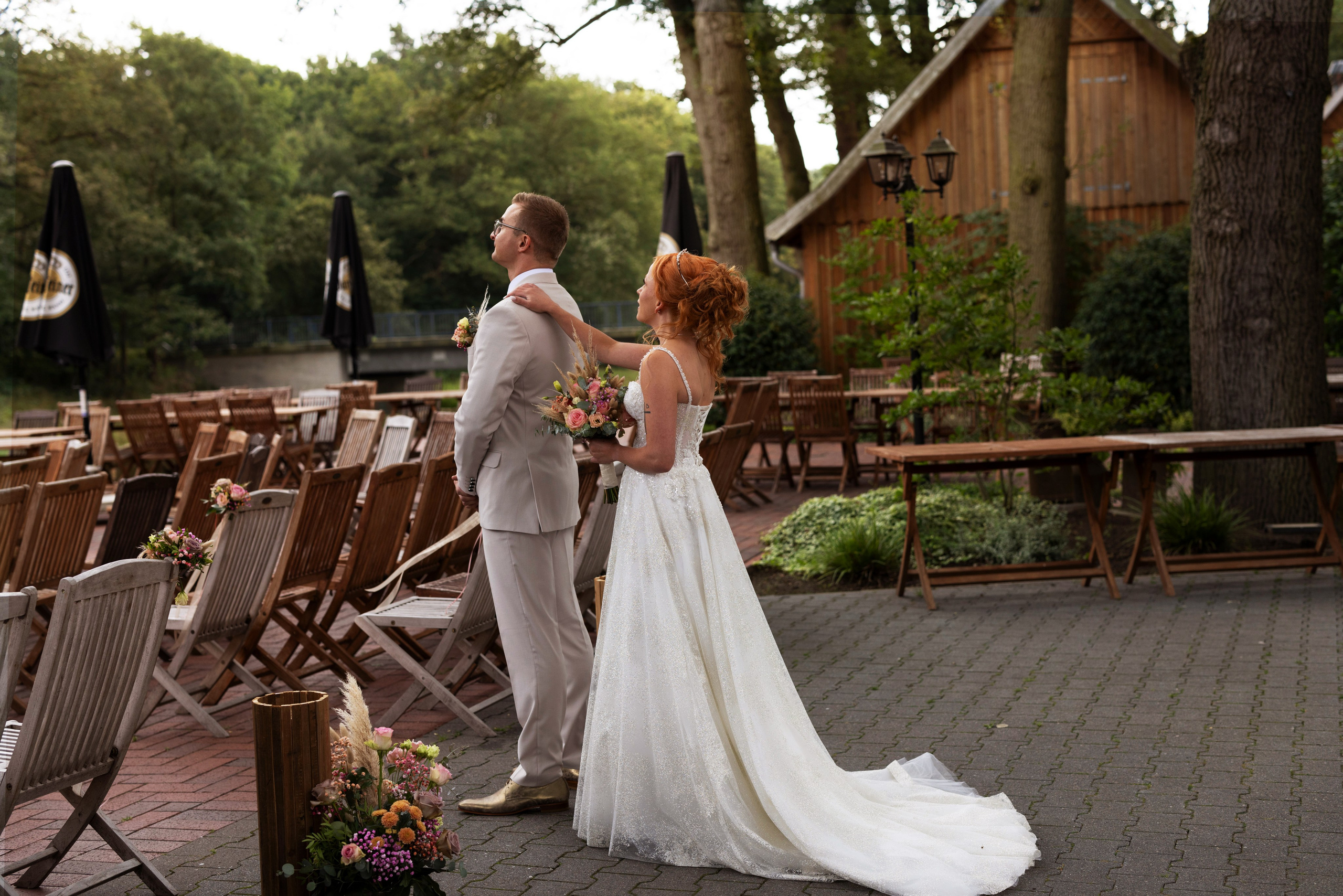 Rustikale Kulisse des Artland Kotten für eine romantische freie Trauung im Grünen, mit Holzscheunen im Hintergrund.“