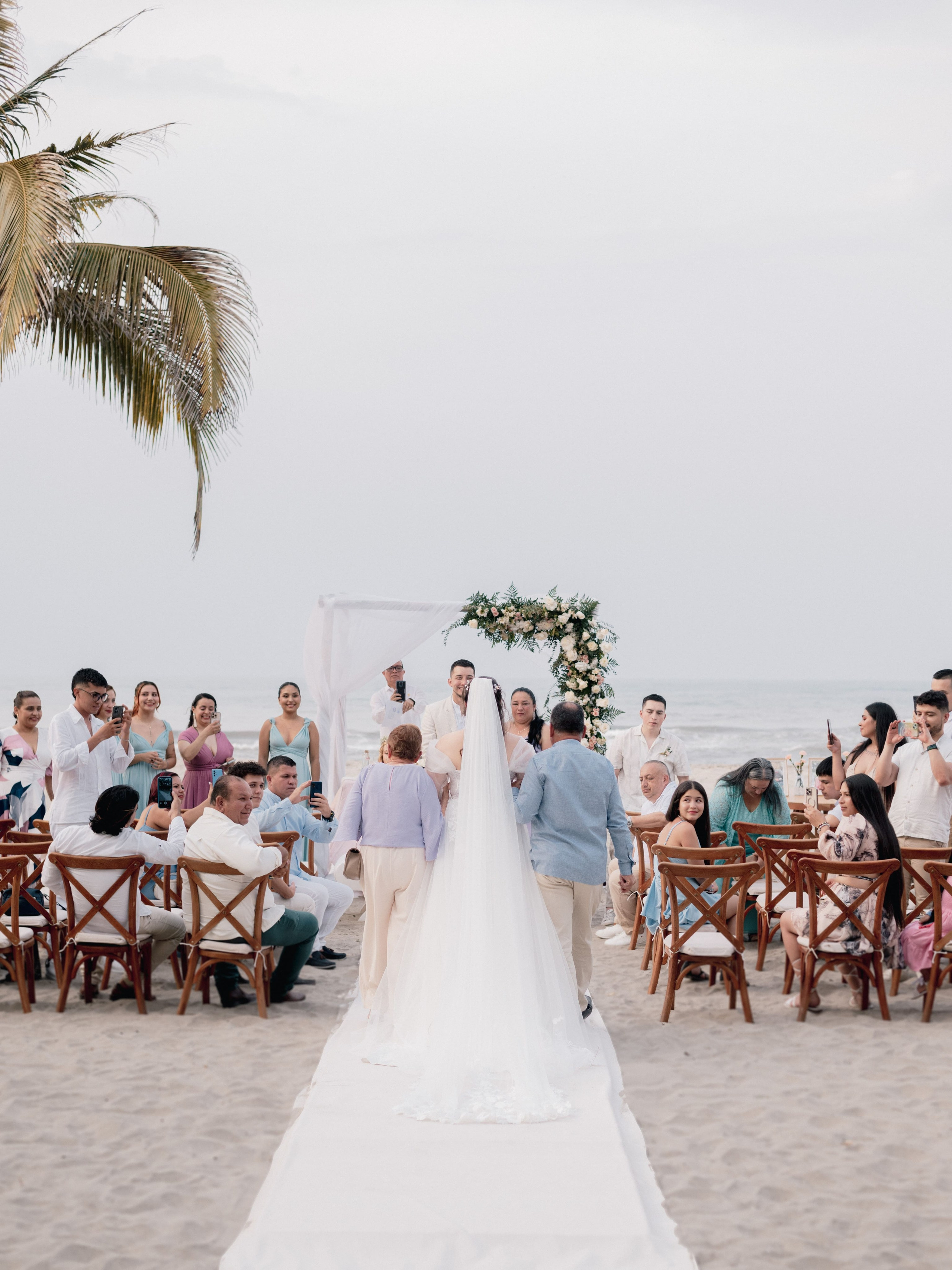 Decoración de mesa con palmeras en recepción de boda de playa, ambiente tropical montado para fiesta