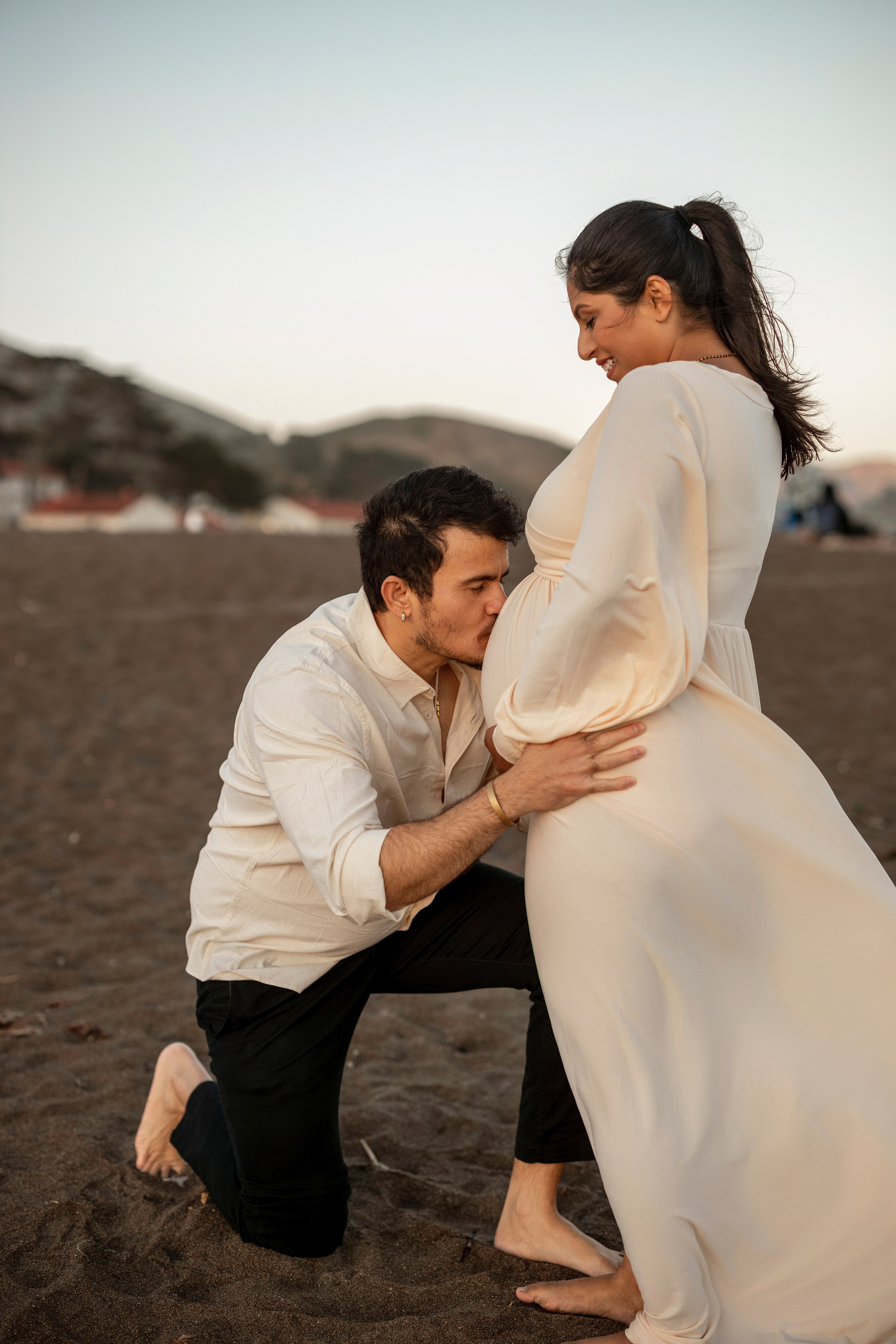 Mom-to-be and partner enjoying maternity session on California coast