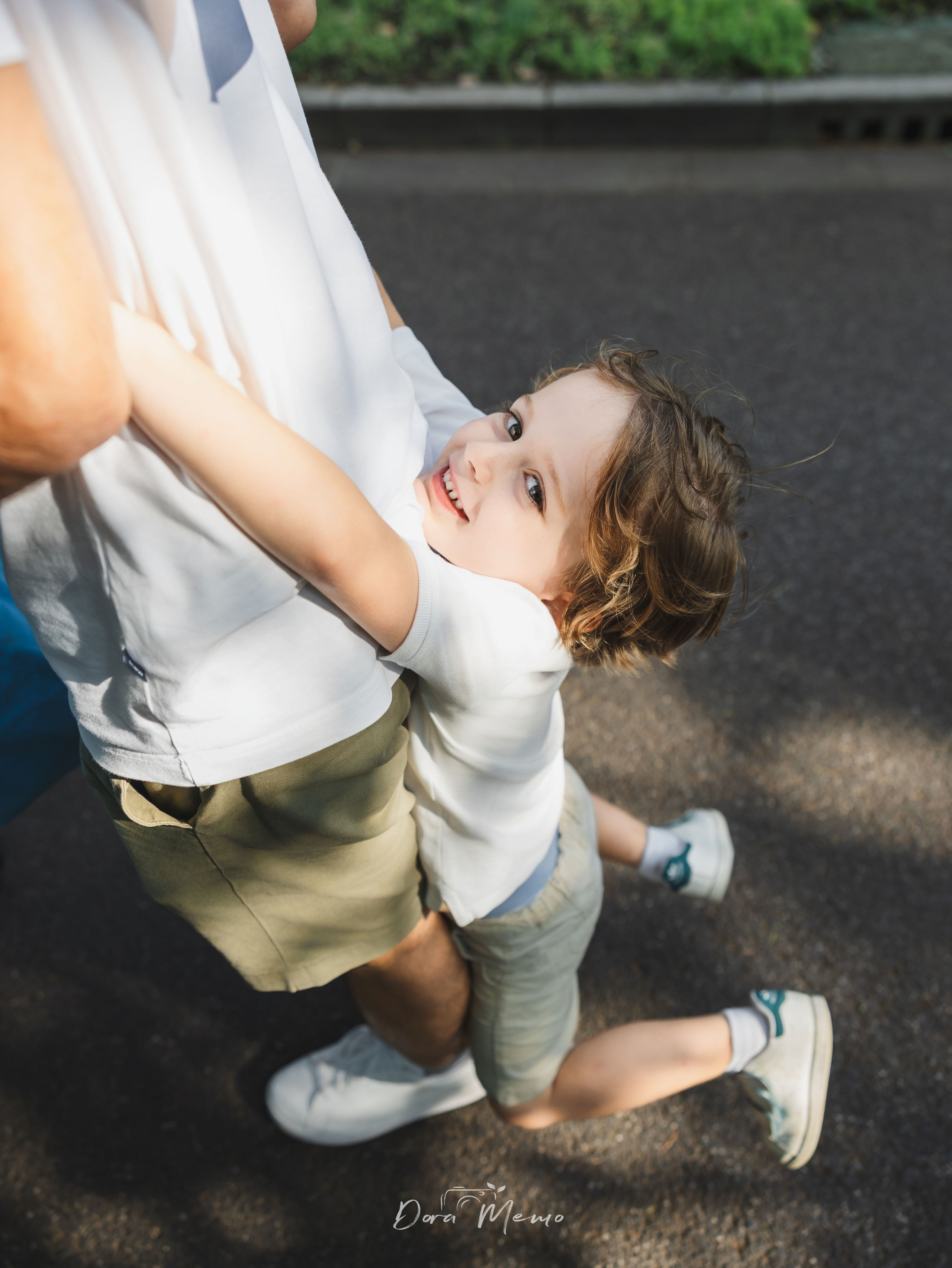 Child hugging dad from behind | Child embracing father warmly, candid tender moment 