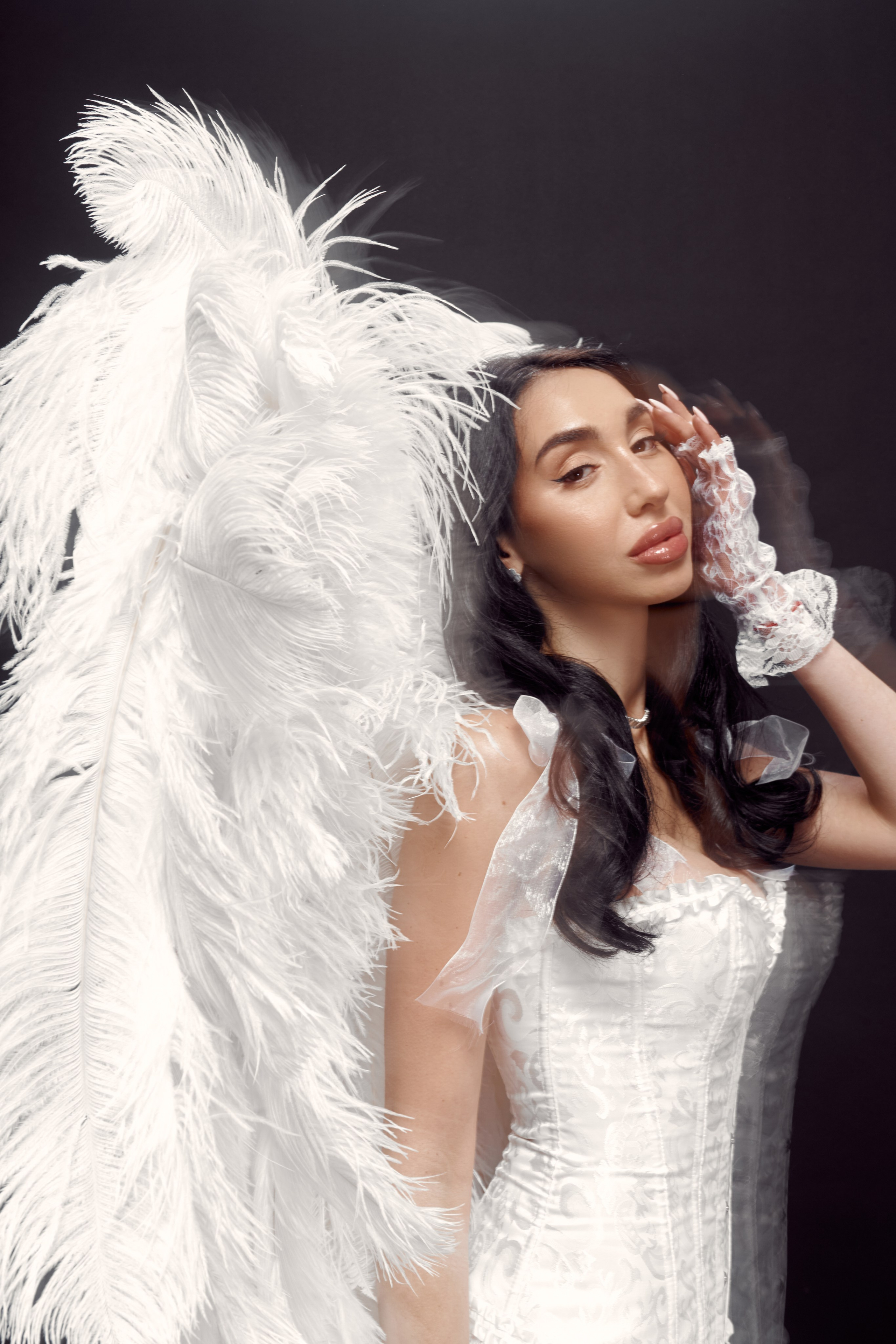 Creative studio portrait of Ester Rogovaya with angel wings, intentional blur and dynamic movement