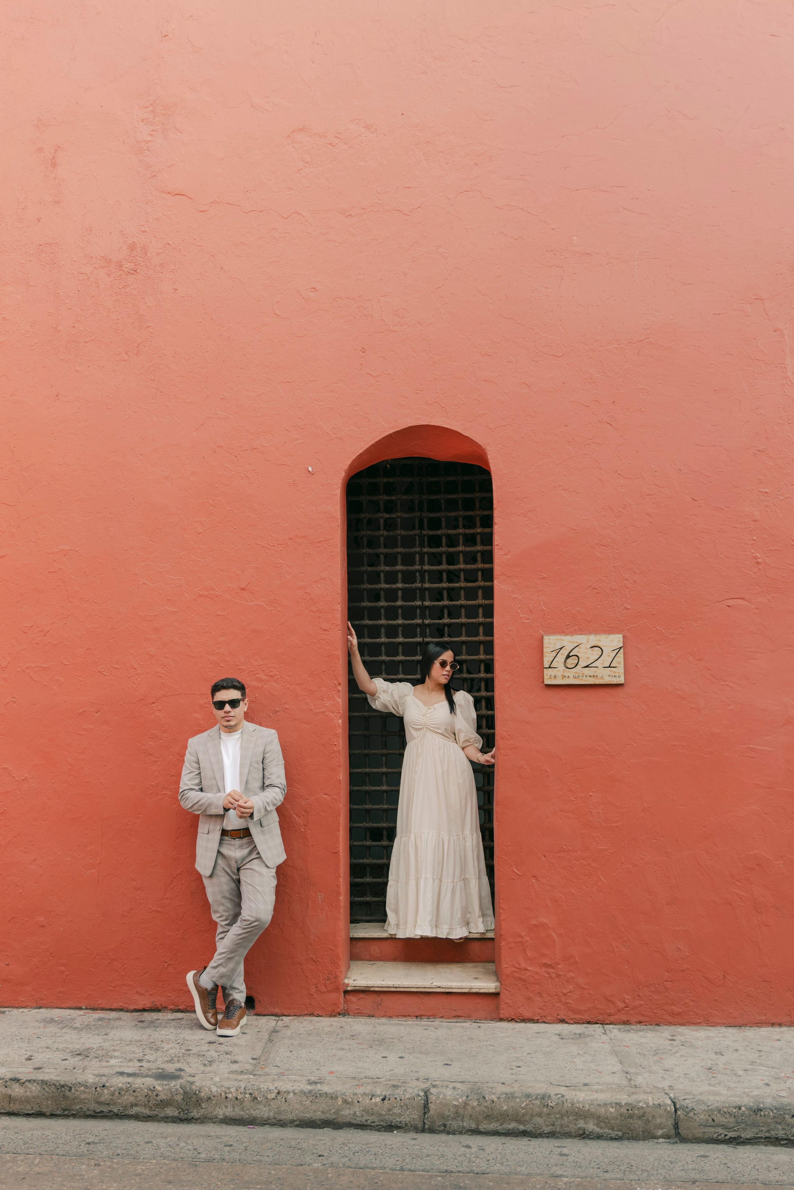 Novios sonriendo entre plantas tropicales, fotografía de preboda natural cinematográfica