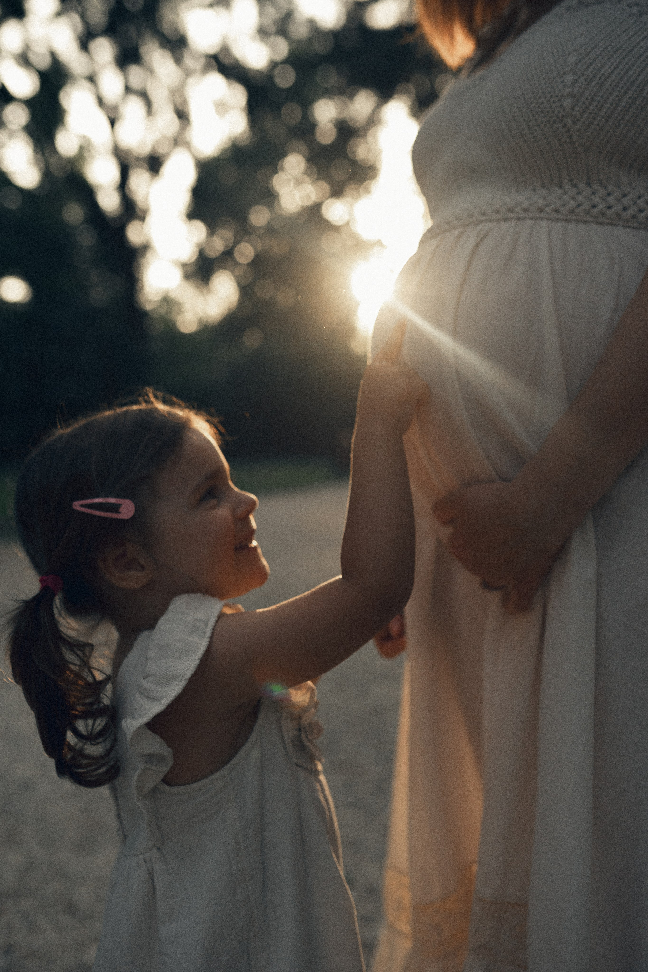 Shooting gravidanza al tramonto – mamma incinta vestita di bianco tra natura e luce calda