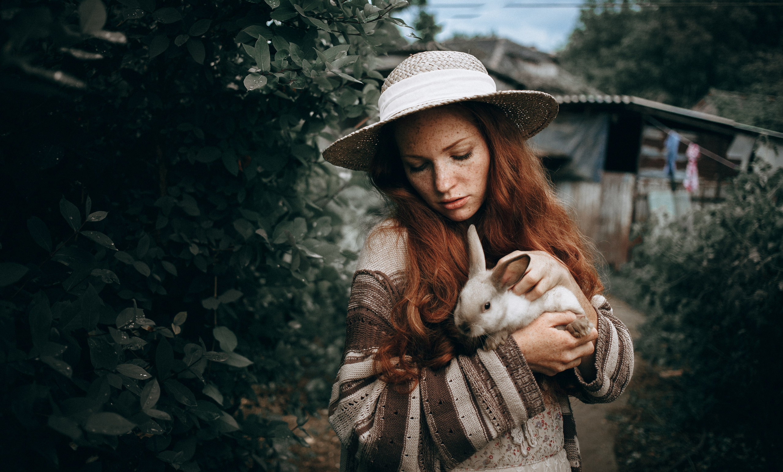 Model posing with a fluffy white rabbit, highlighting the gentle bond between the animal and the person. The serene setting accentuates the soft fur of the rabbit and the model's peaceful expression. This image captures the essence of companionship and the beauty of interspecies connection in a tranquil environment.