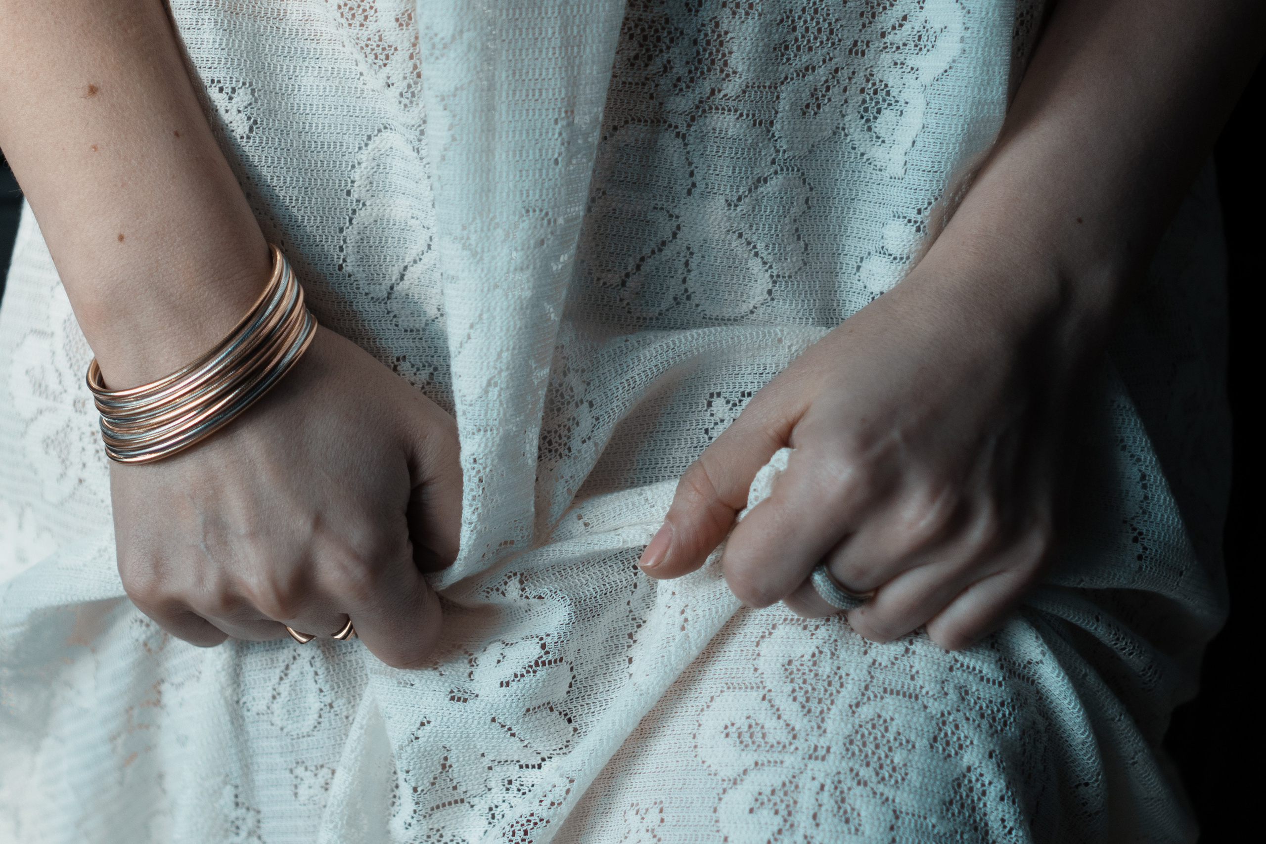 Detailaufnahme Hände im weißen Spitzenkleid, zarte Geste – kreative Portraitfotografie