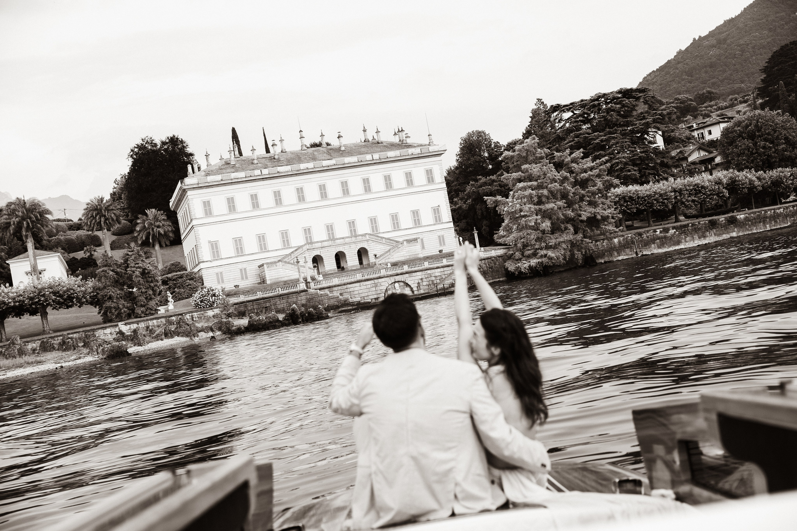 Newly engaged couple admiring Villa Melzi from a private boat on Lake Como