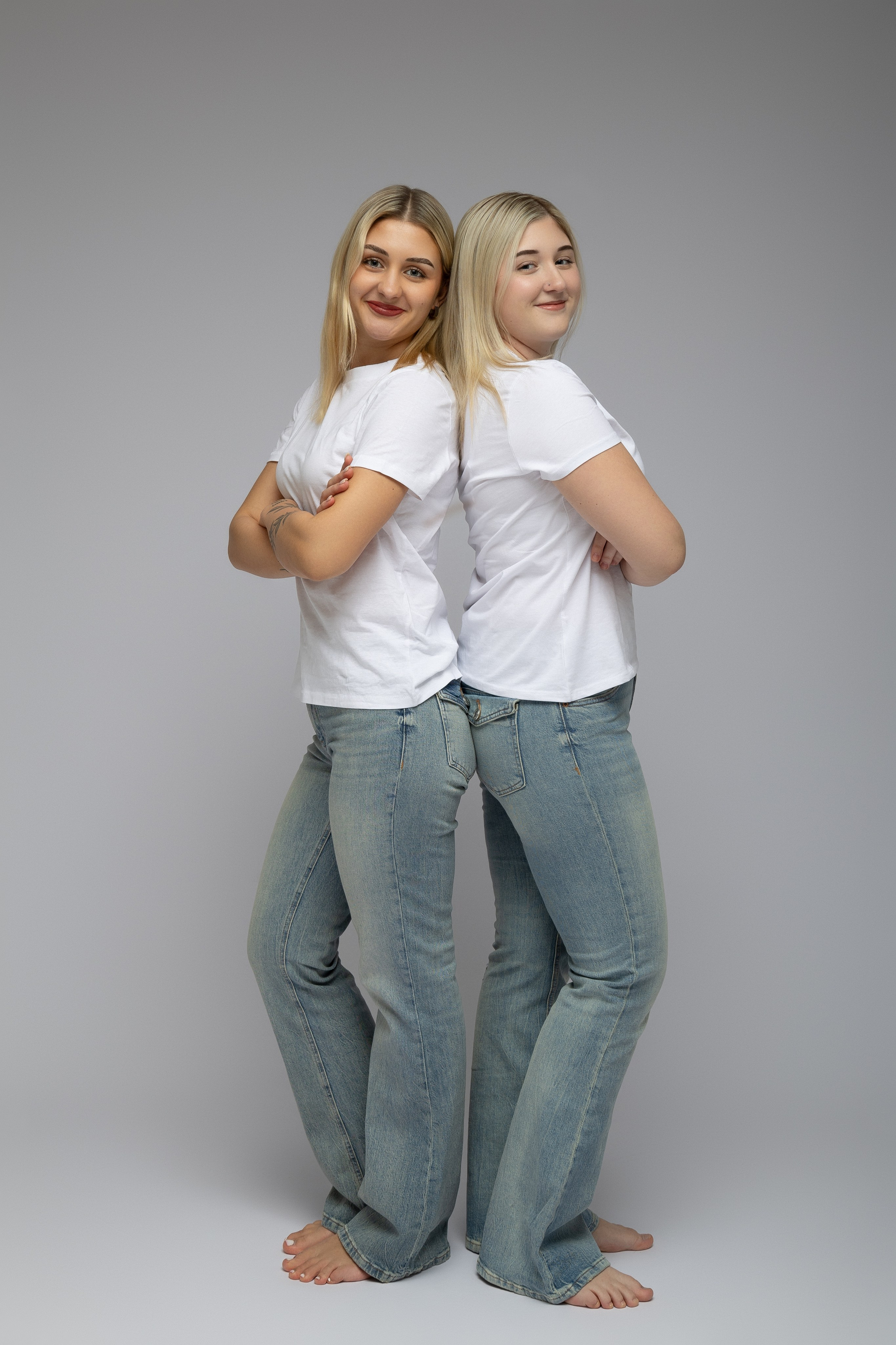 Zwei Schwestern bei einer Studio-Fotosession, natürliches Porträt auf weißem Hintergrund