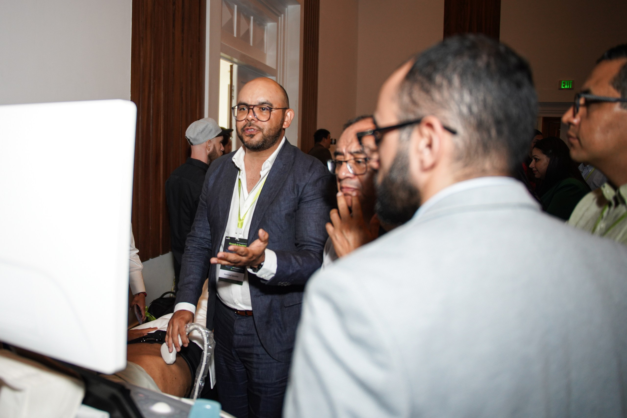 Presenter showing features of advanced ultrasound equipment to attendees.