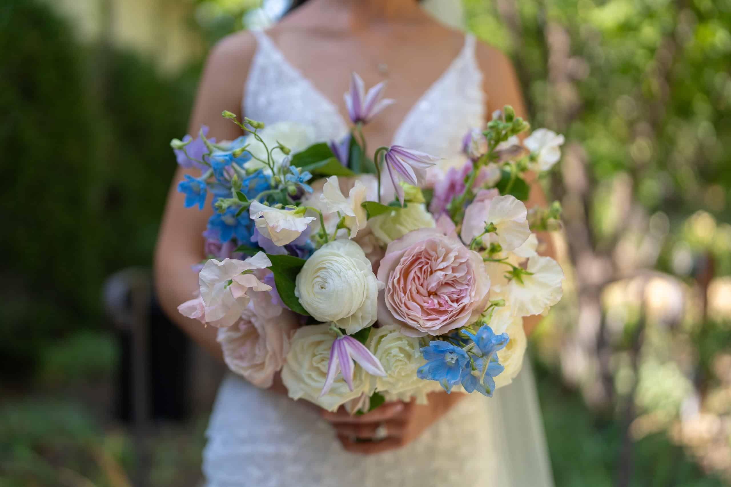 Artistic bouquet close-up with cream roses and blue accents