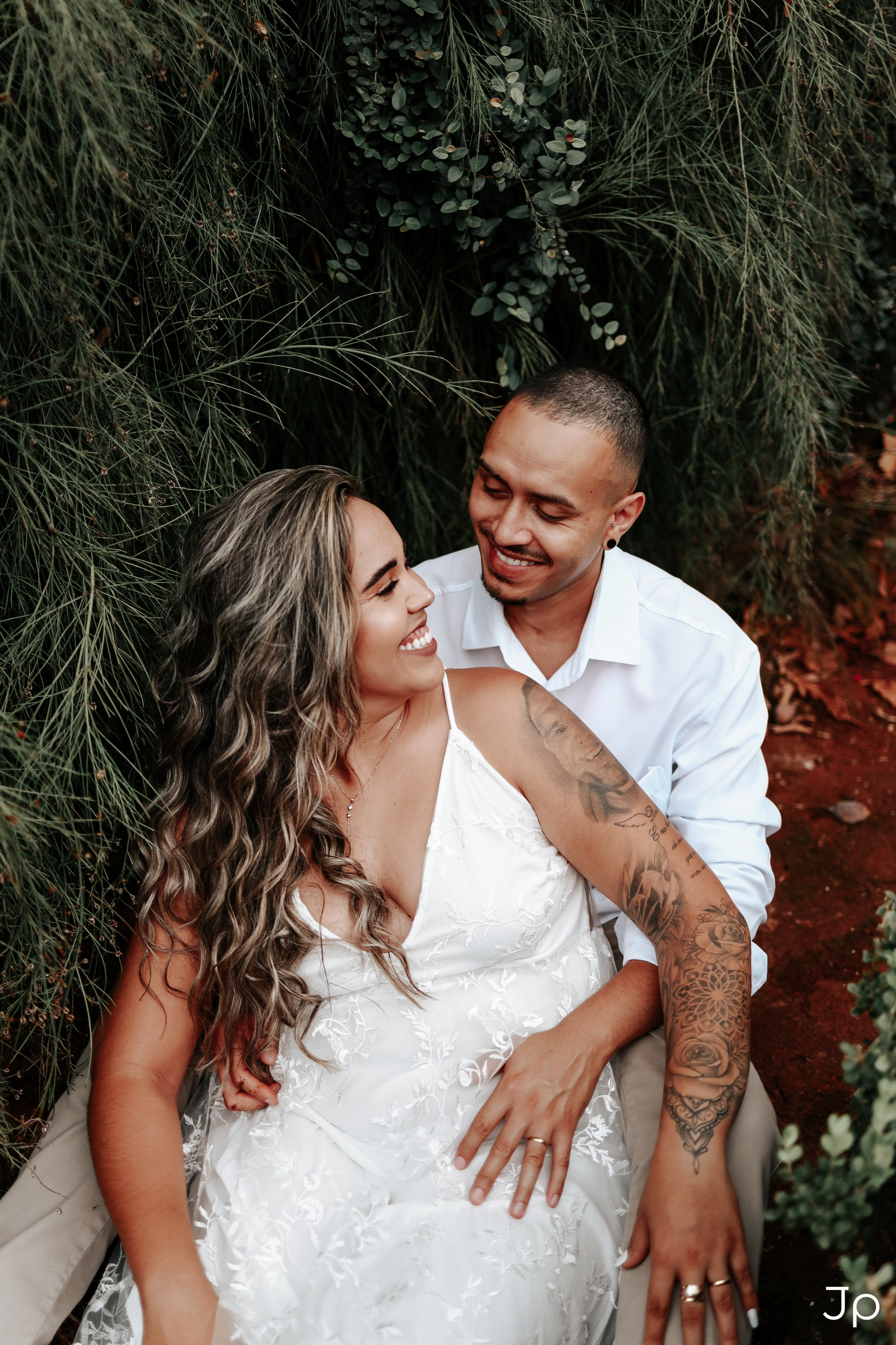 Fotógrafo de casamentos em Pederneiras registra casal sorrindo em meio à vegetação.
