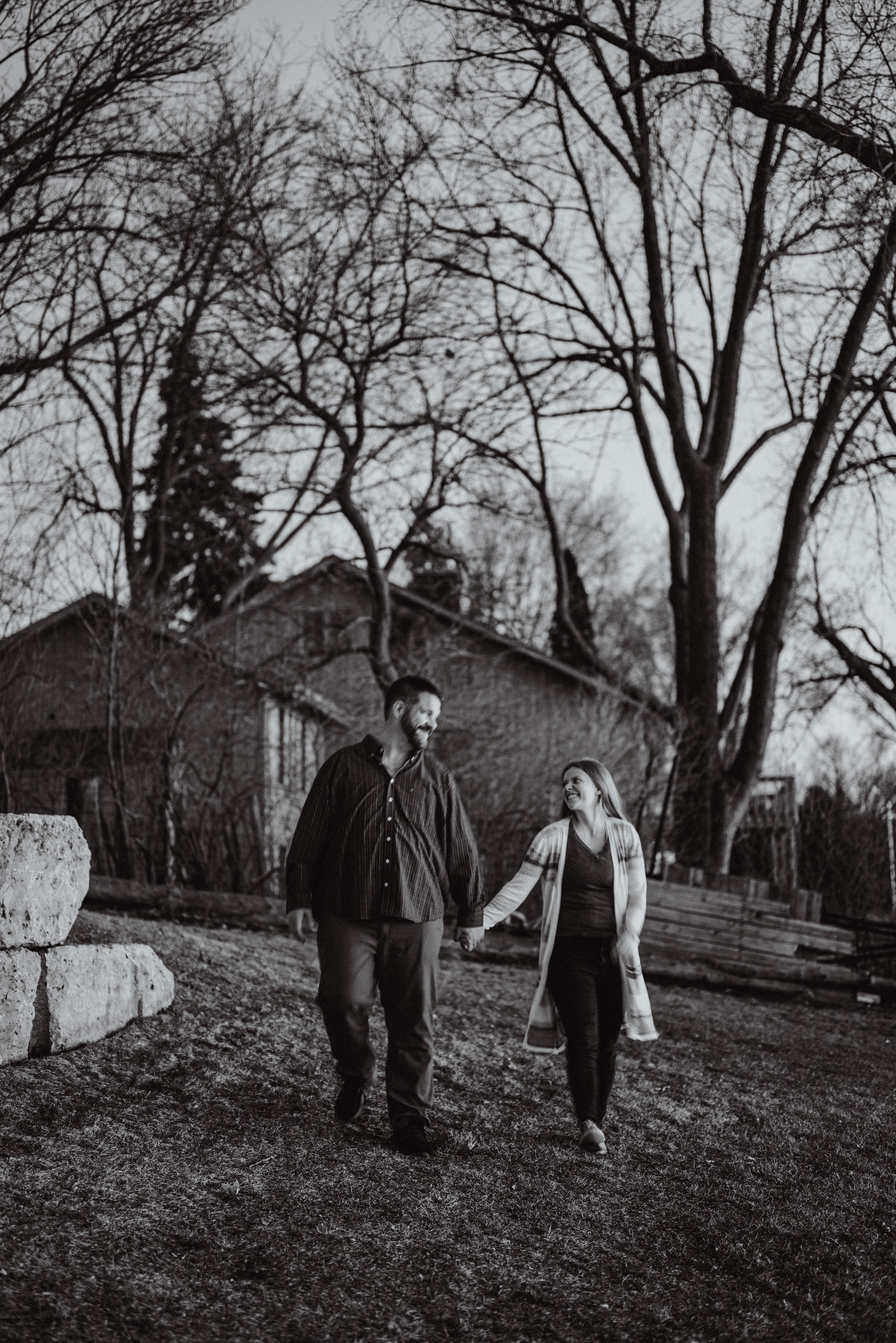 Couple sharing an intimate moment during an outdoor engagement session in De Pere, captured in soft evening light.